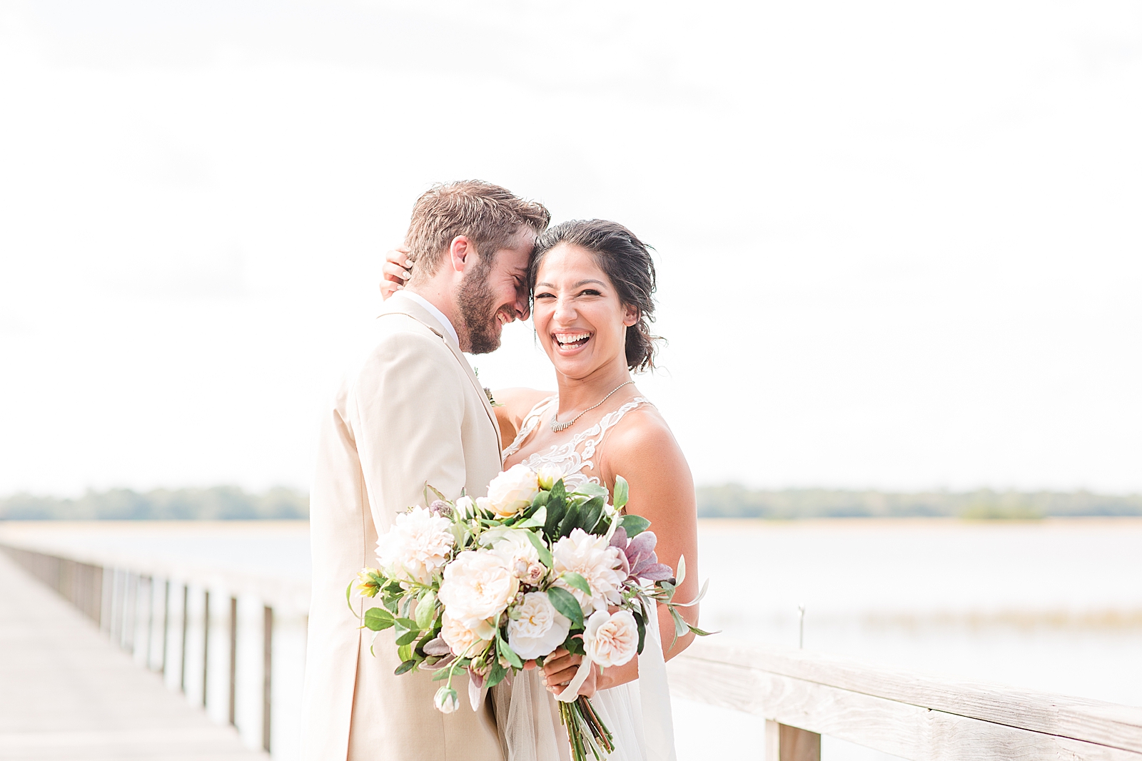 Charleston Wedding at Lowndes Grove Bride laughing over Groom shoulder on dock photo