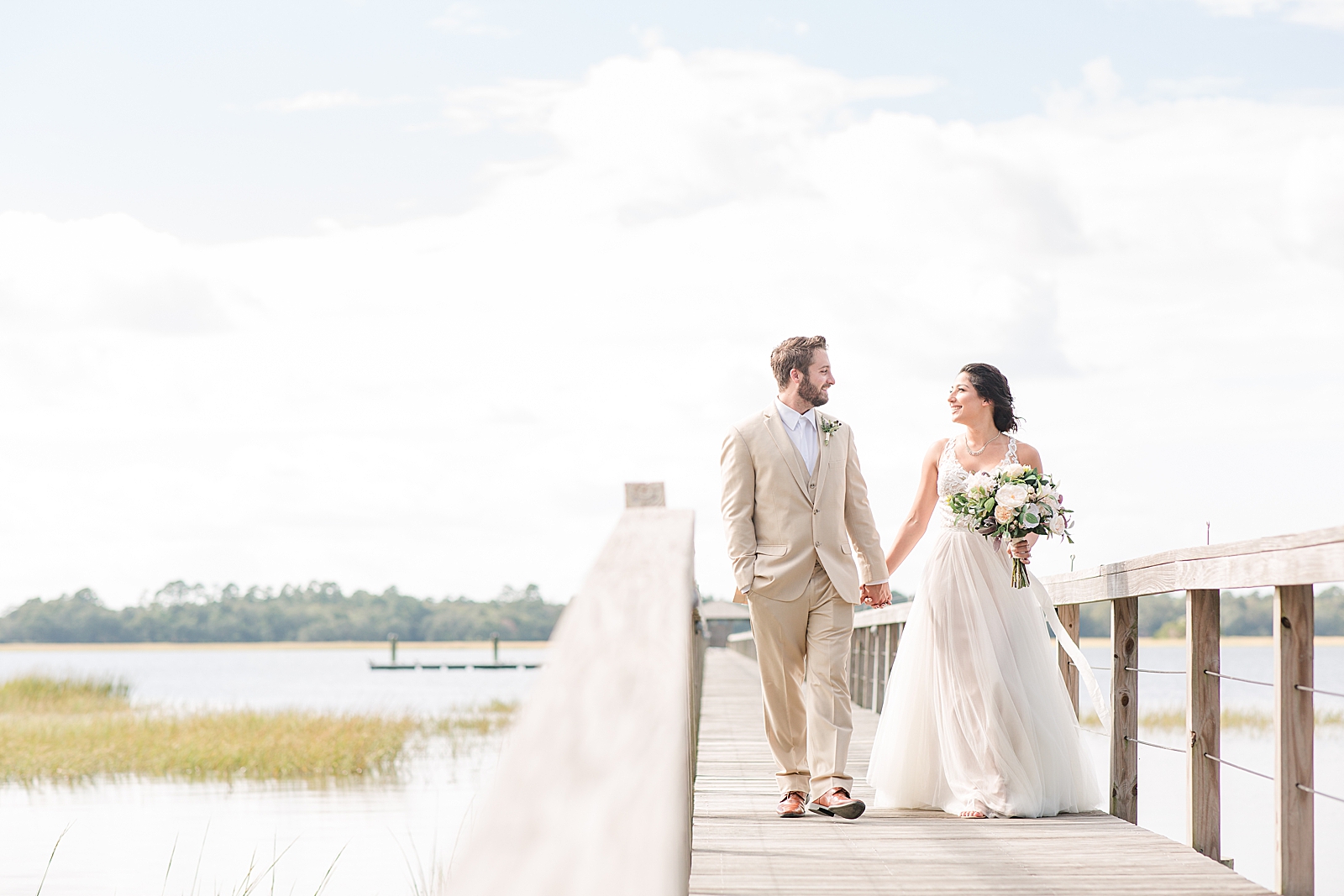Charleston Wedding at Lowndes Grove Bride and Groom walking hand in hand down the dock Photo