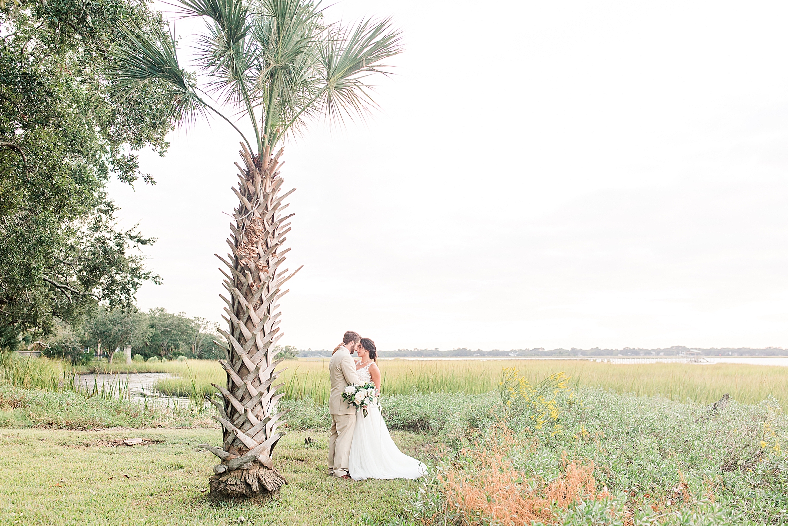 Charleston Wedding at Lowndes Grove Bride and Groom nose to nose by palm tree on the Ashley River Photo
