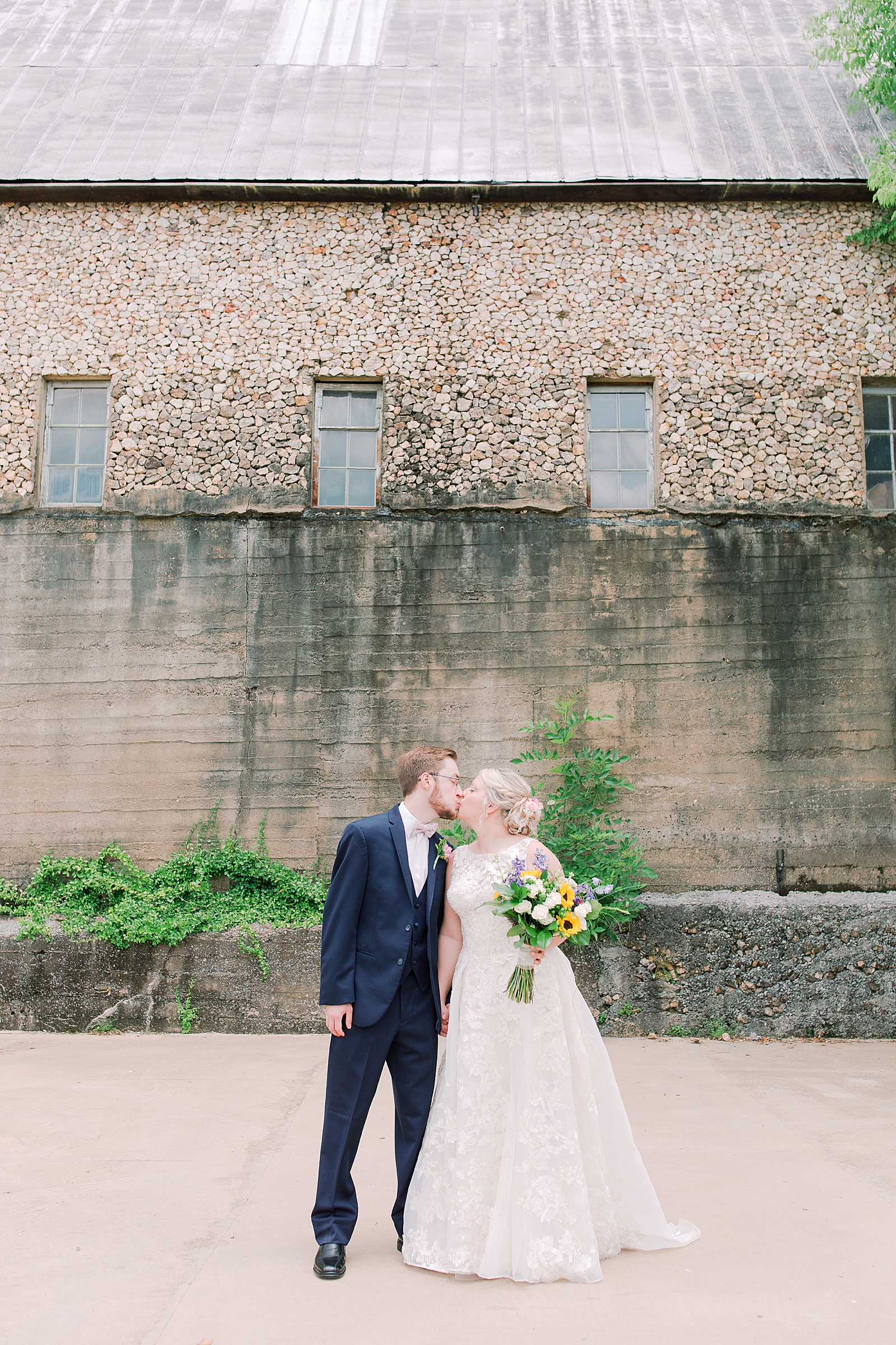 Black Fox Farms Garden Wedding Bride and Groom Kissing in Front of Old Building Photo
