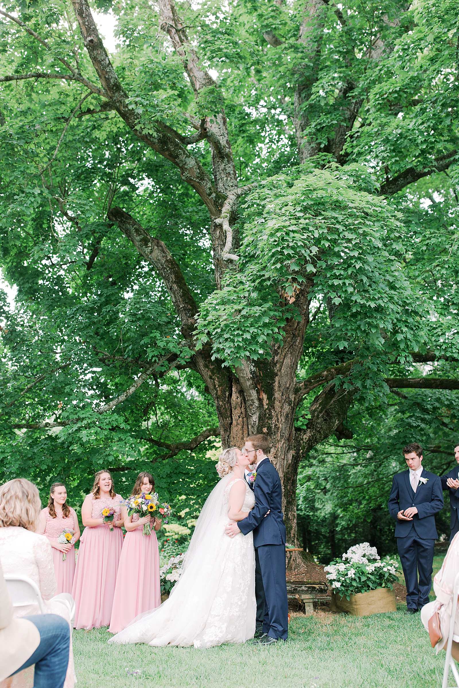 Black Fox Farms Garden Wedding Ceremony Bride and Groom First Kiss Under Big Tree Photo