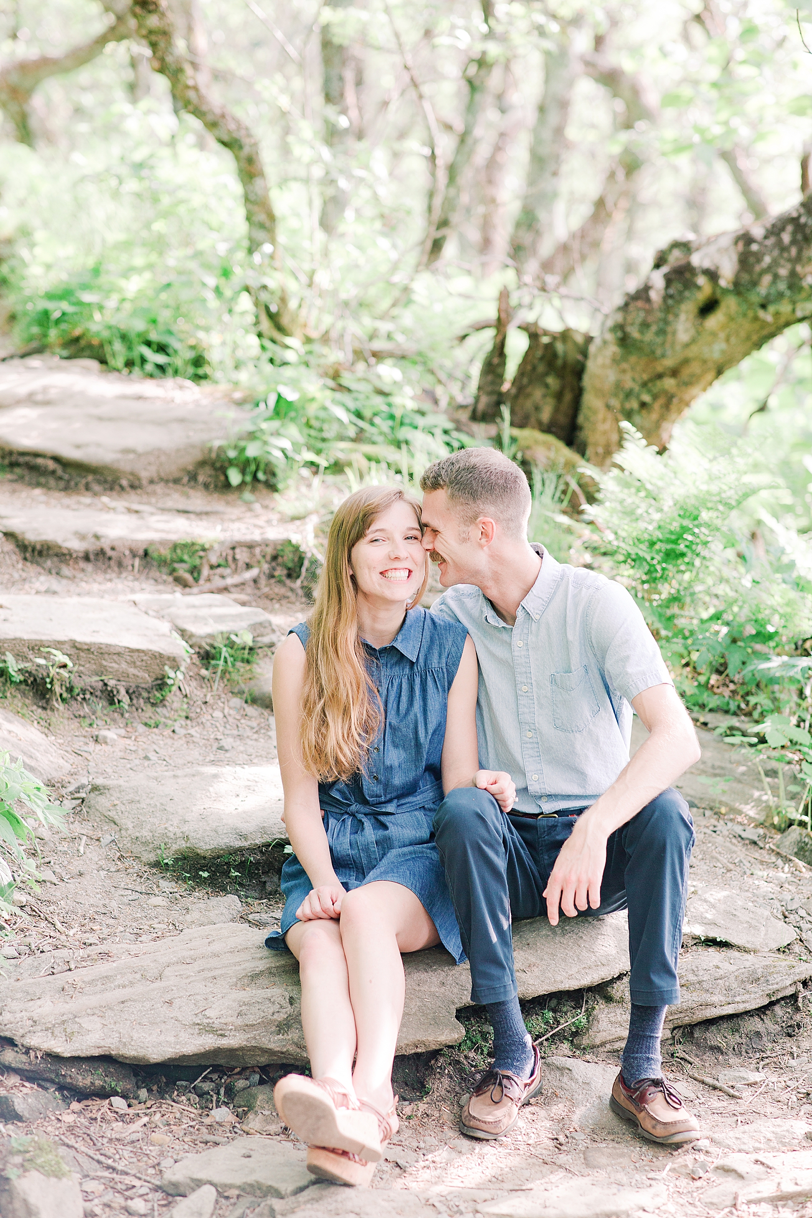 Craggy Gardens Engagement Couple Sitting on Rocks in Woods Snuggling Photo