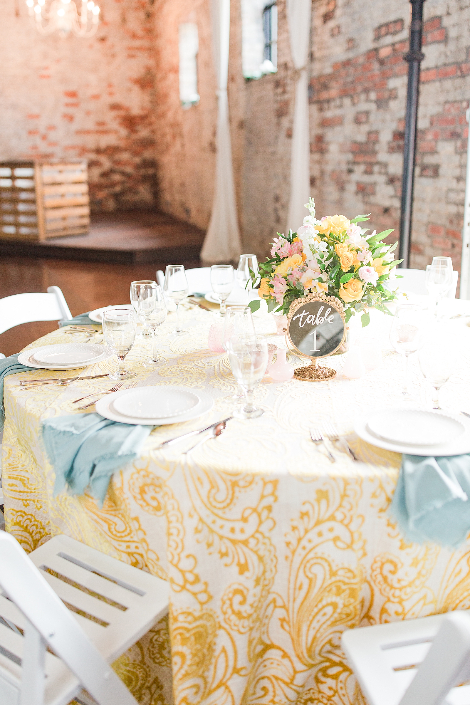 Hackney Warehouse Wedding Reception table with yellow table cloth and blue napkins Photo
