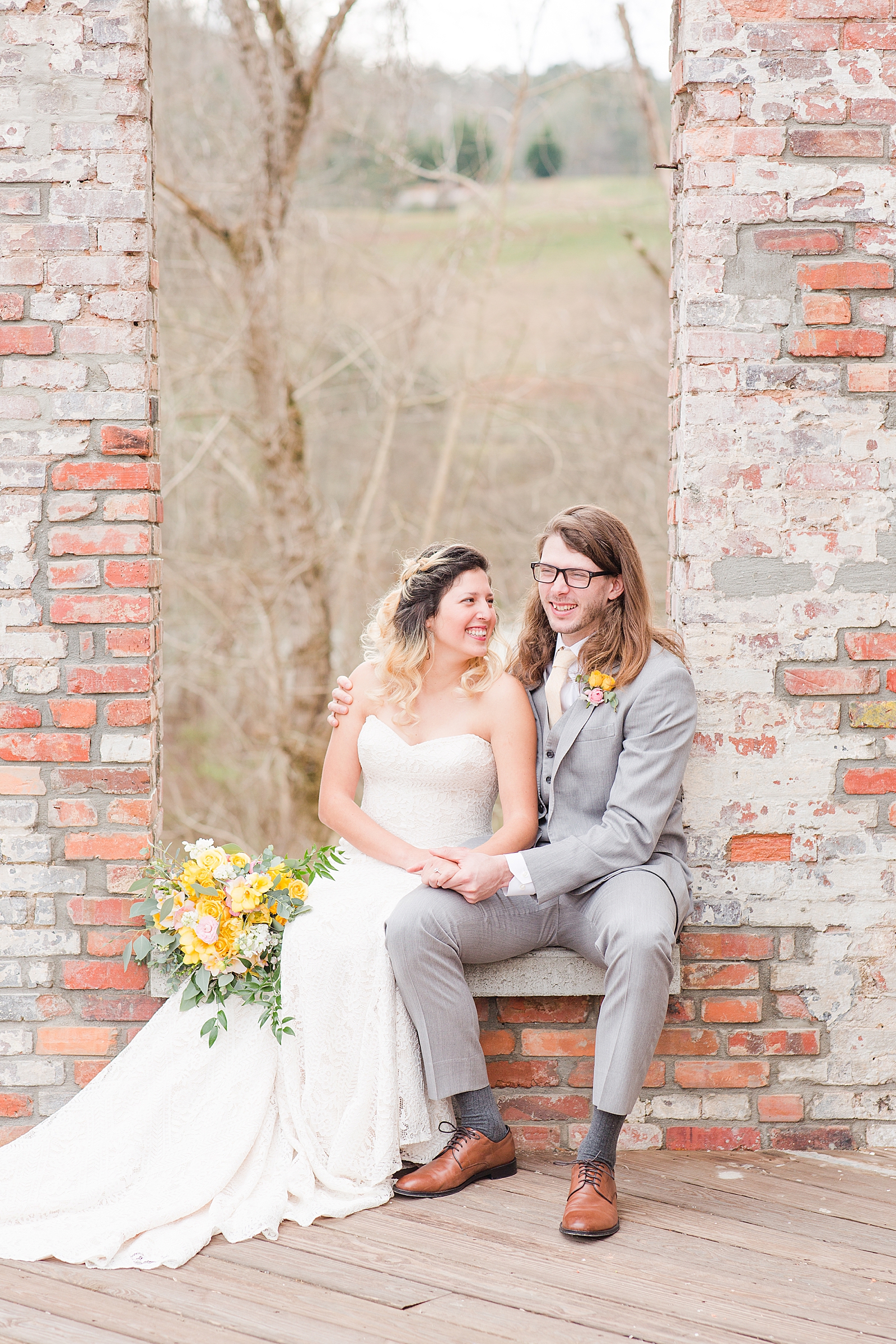 Hackney Warehouse Wedding Bride and Groom Sitting in Window Laughing holding hands Photo