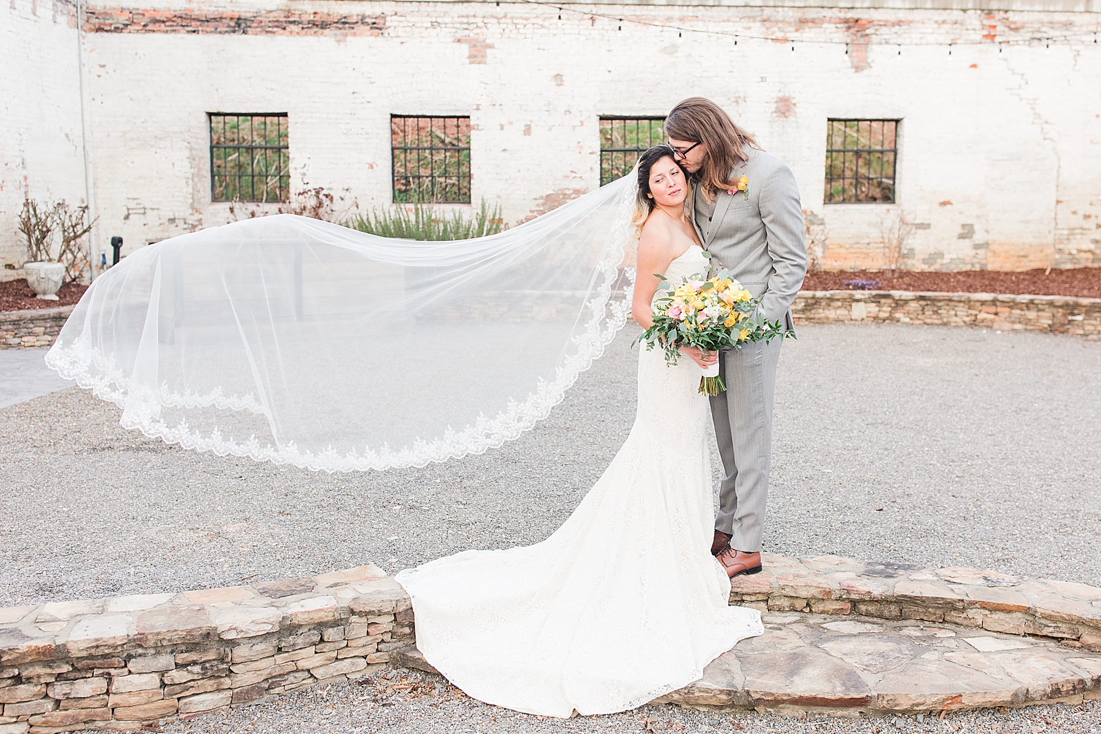 Hackney Warehouse Wedding Couple hugging with brides veil blowing in the wind Photo