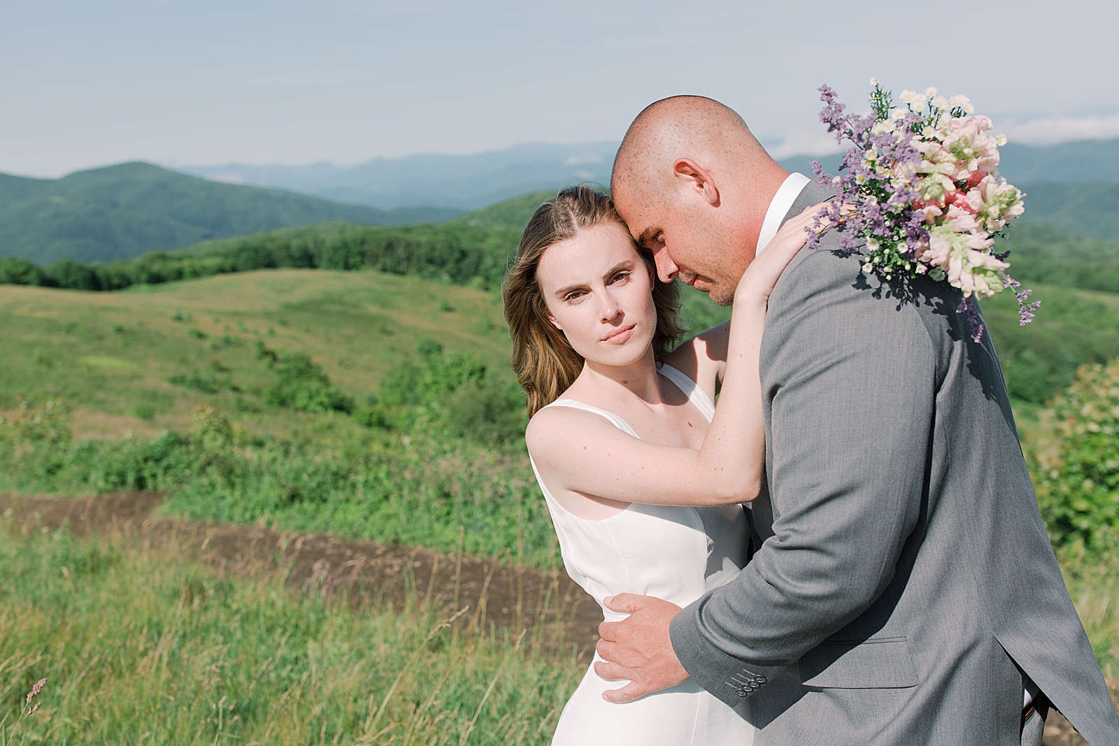 Max Patch Elopement Bride Looking at The Camera While Groom Nuzzles In Photo
