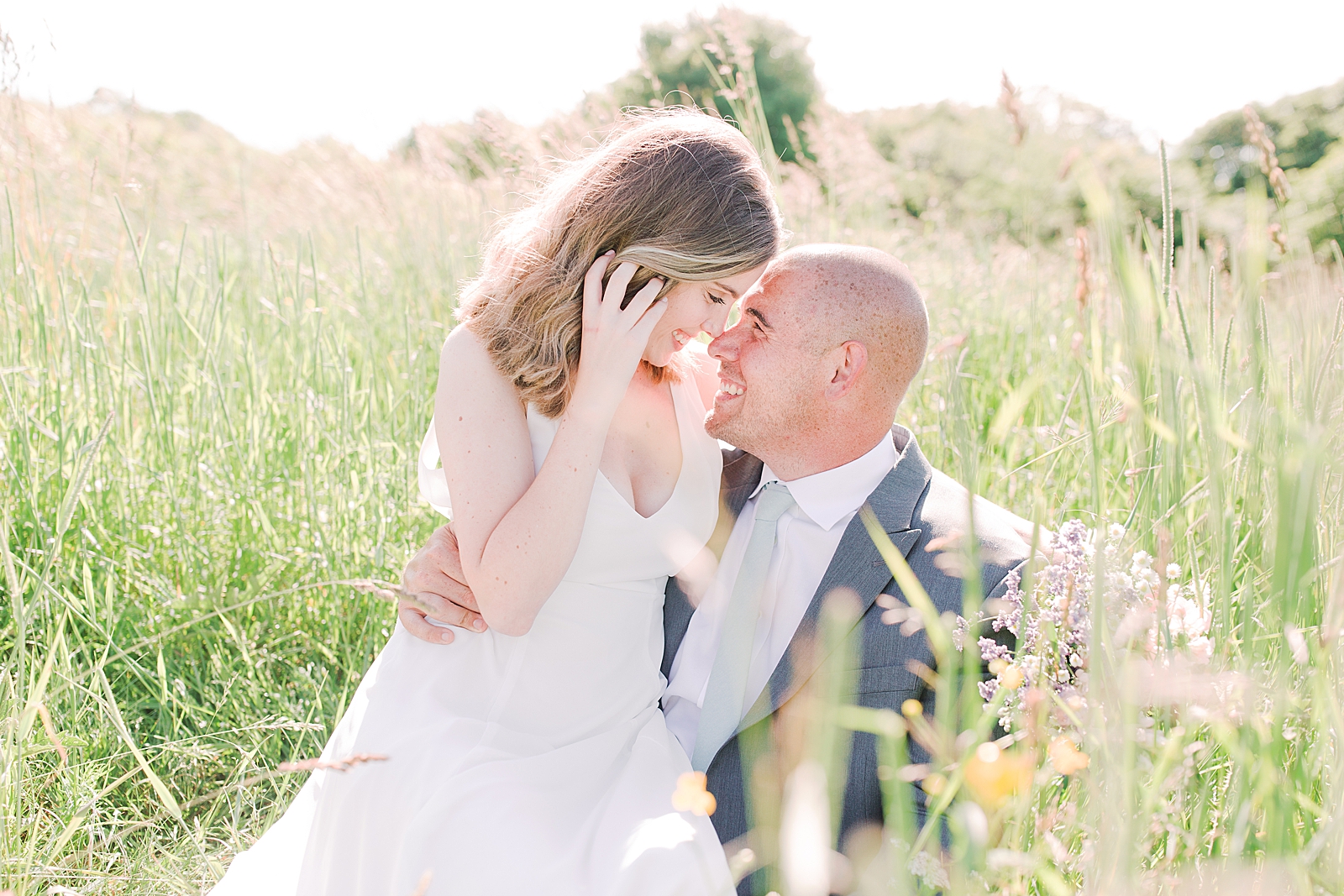 Max Patch Elopement Bride and Groom Sitting in Grass Smiling Photo