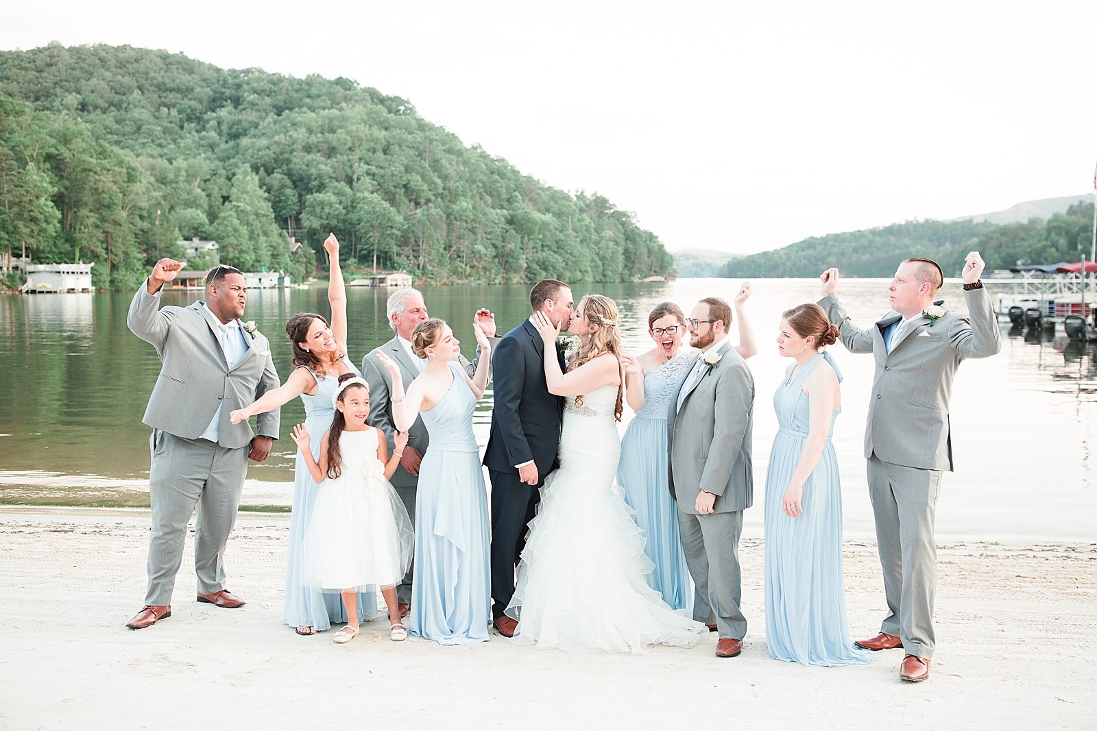 Rumbling Bald Resort Wedding Bride and Groom Kissing and Bridal Party Cheering on Beach Photo