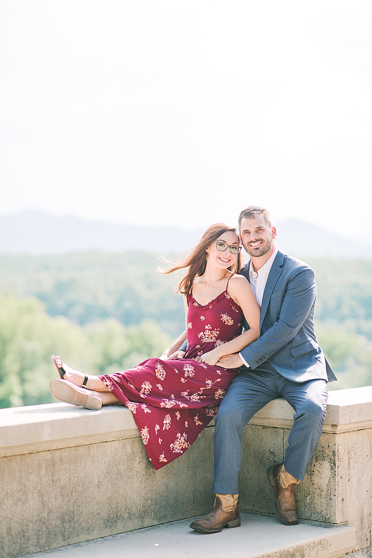 Biltmore Estate Anniversary Session Couple sitting on wall with mountains in the background Photo
