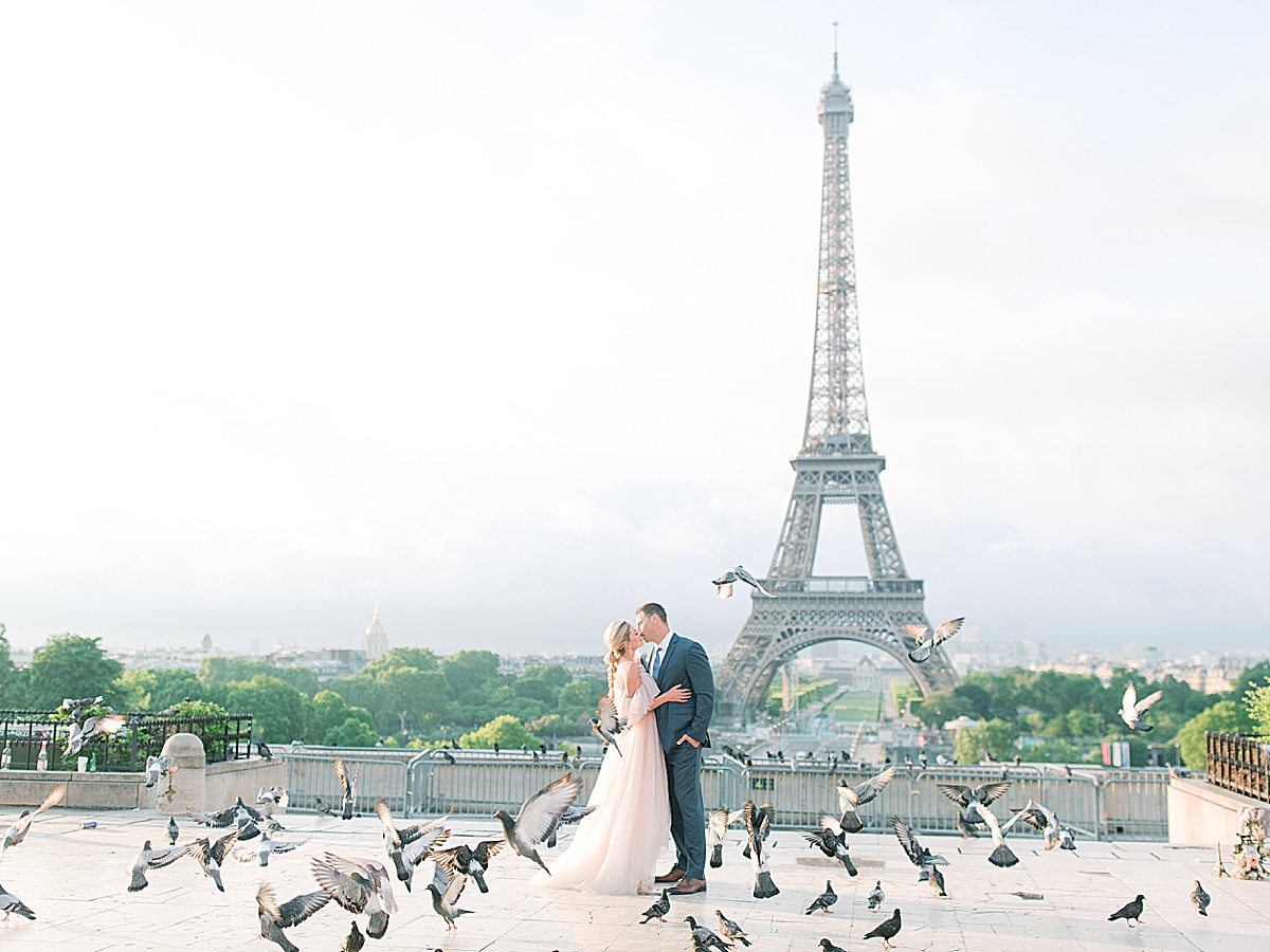 Eiffel Tower Wedding Bride and Groom Kissing With Birds Flying Around Photo