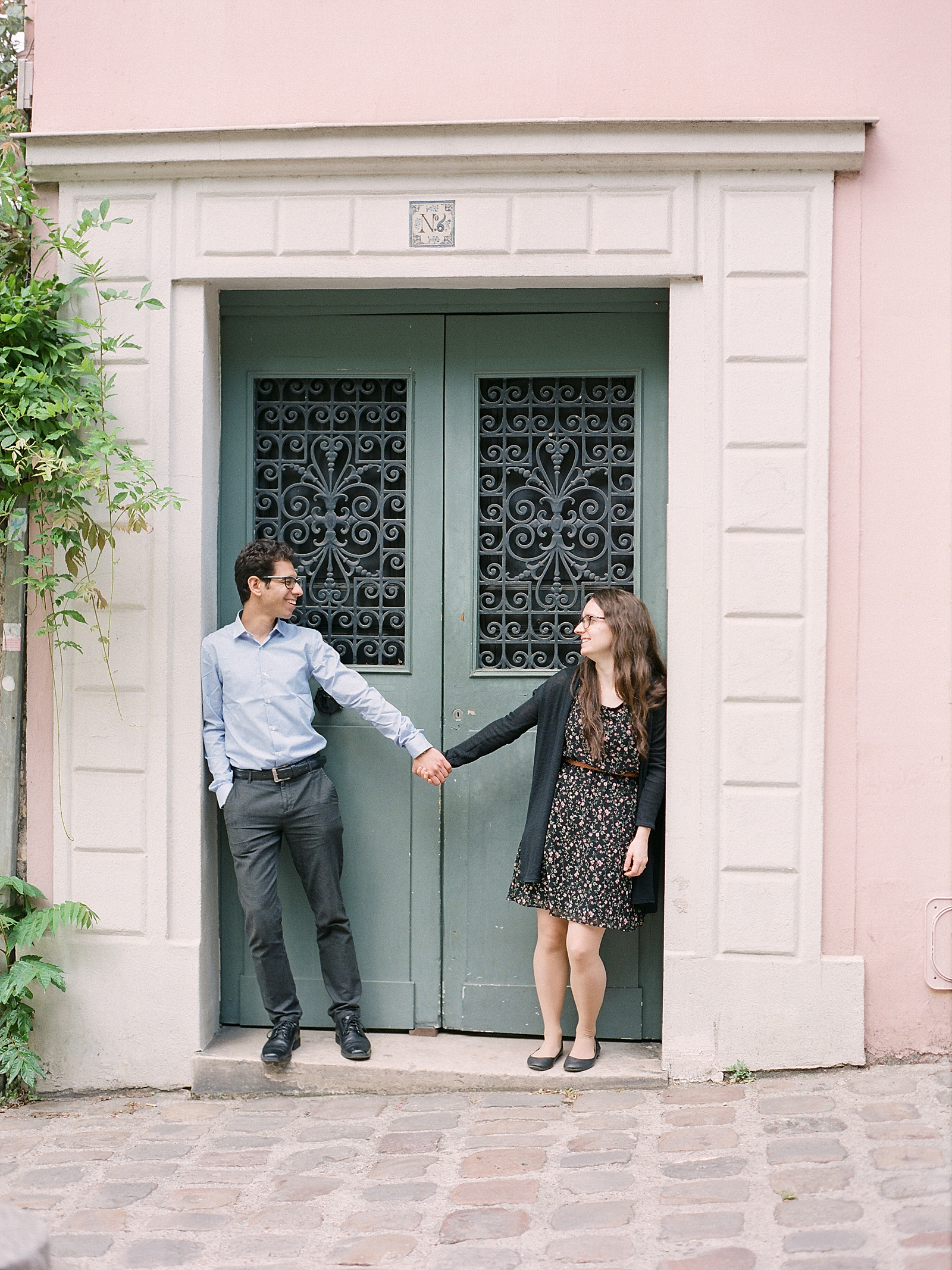 Eiffel Tower Engagement Session Couple holding hands in doorway Photo