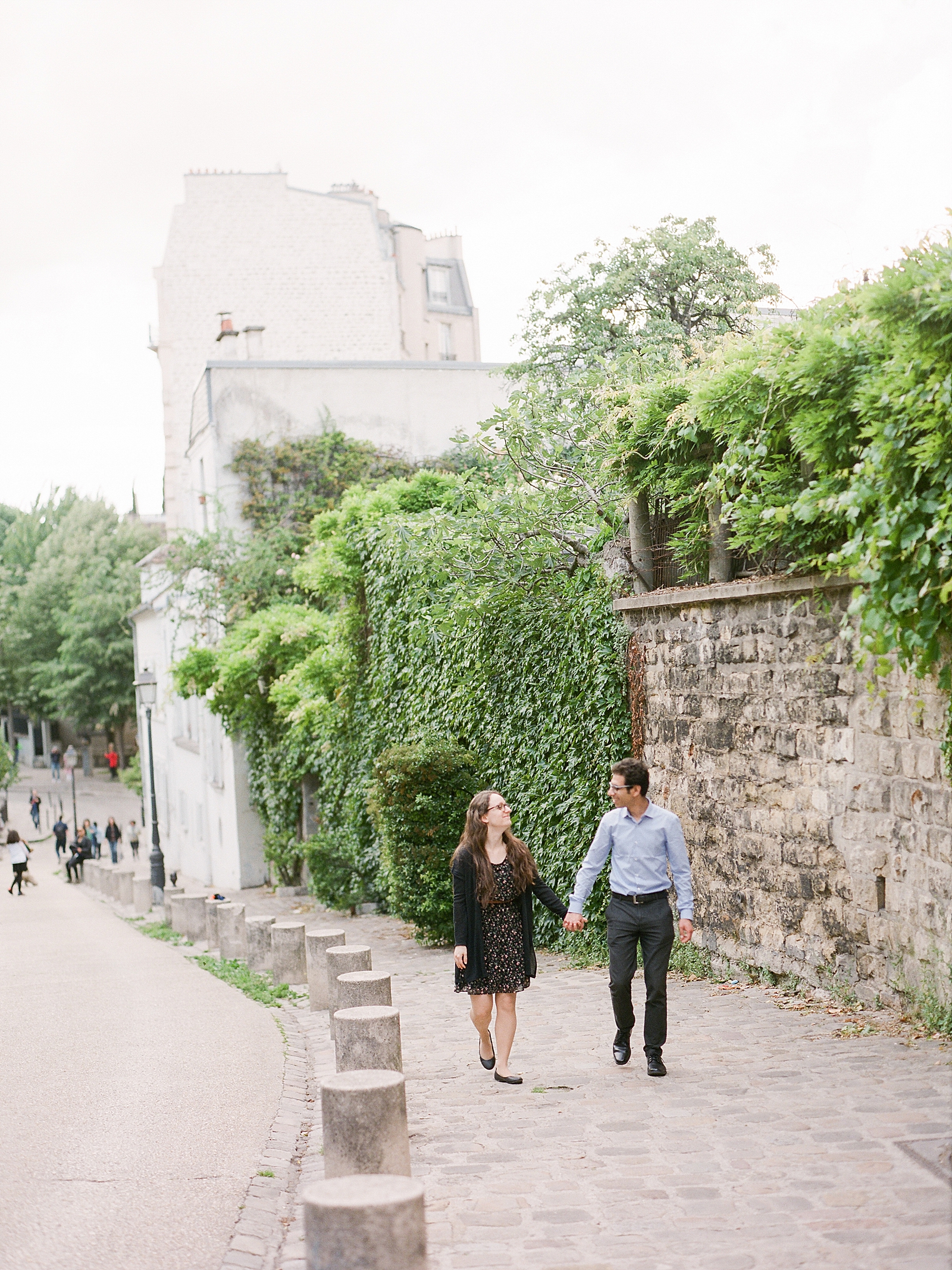Eiffel Tower Engagement Session Couple holding hands walking on sidewalk Photo