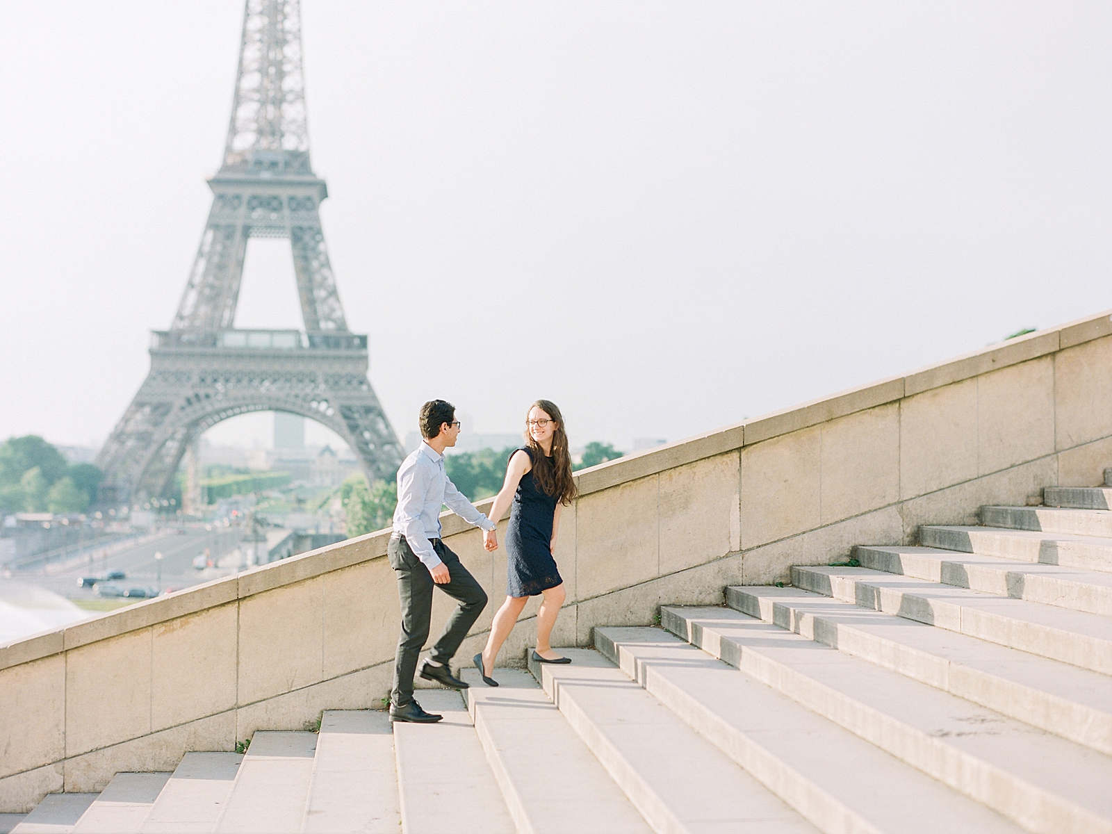 Eiffel Tower Engagement Session Couple walking up steps holding hands Photo