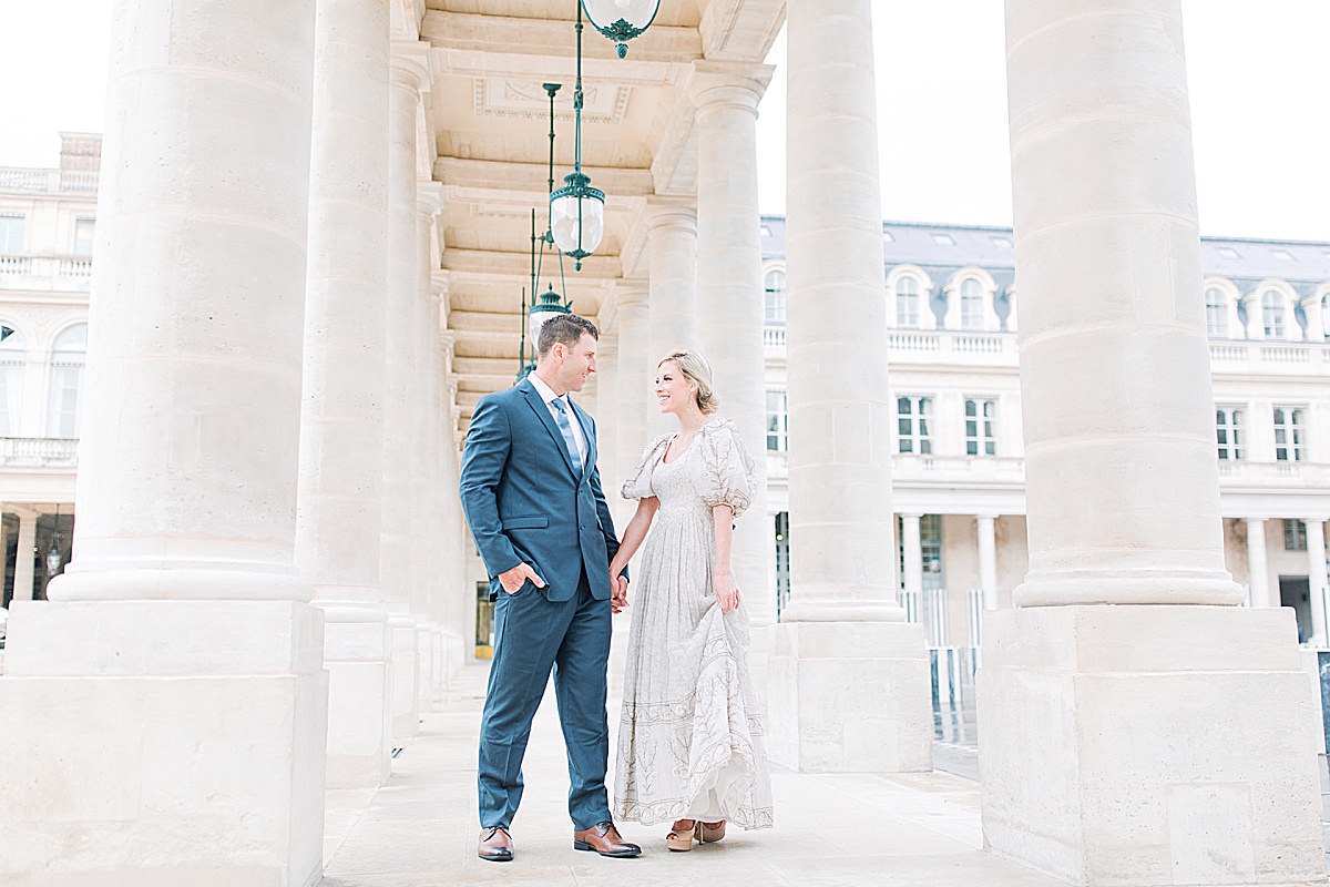 Palais Royal Engagement Couple holding hands smiling at each other in the columns Photo