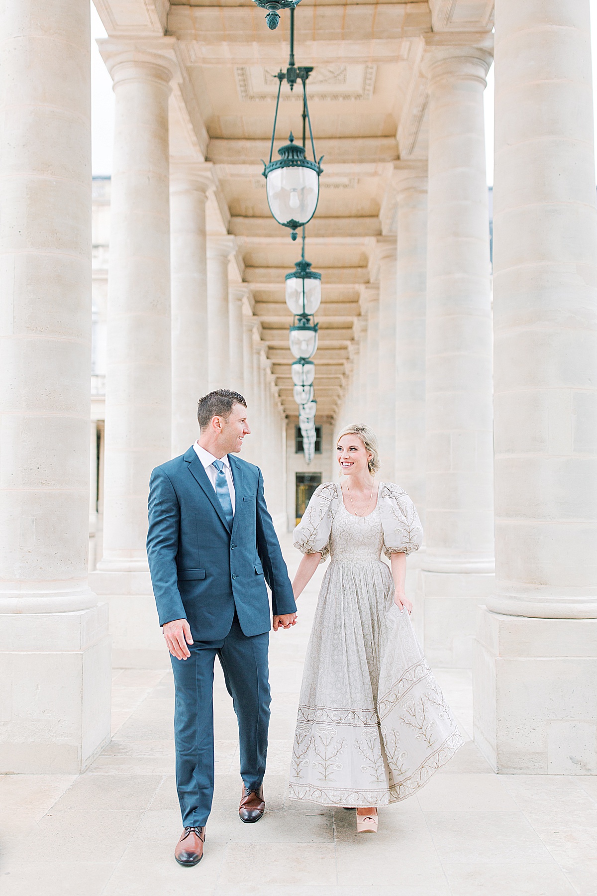 Palais Royal Engagement Couple Smiling at Each other Walking in Between Columns Photo