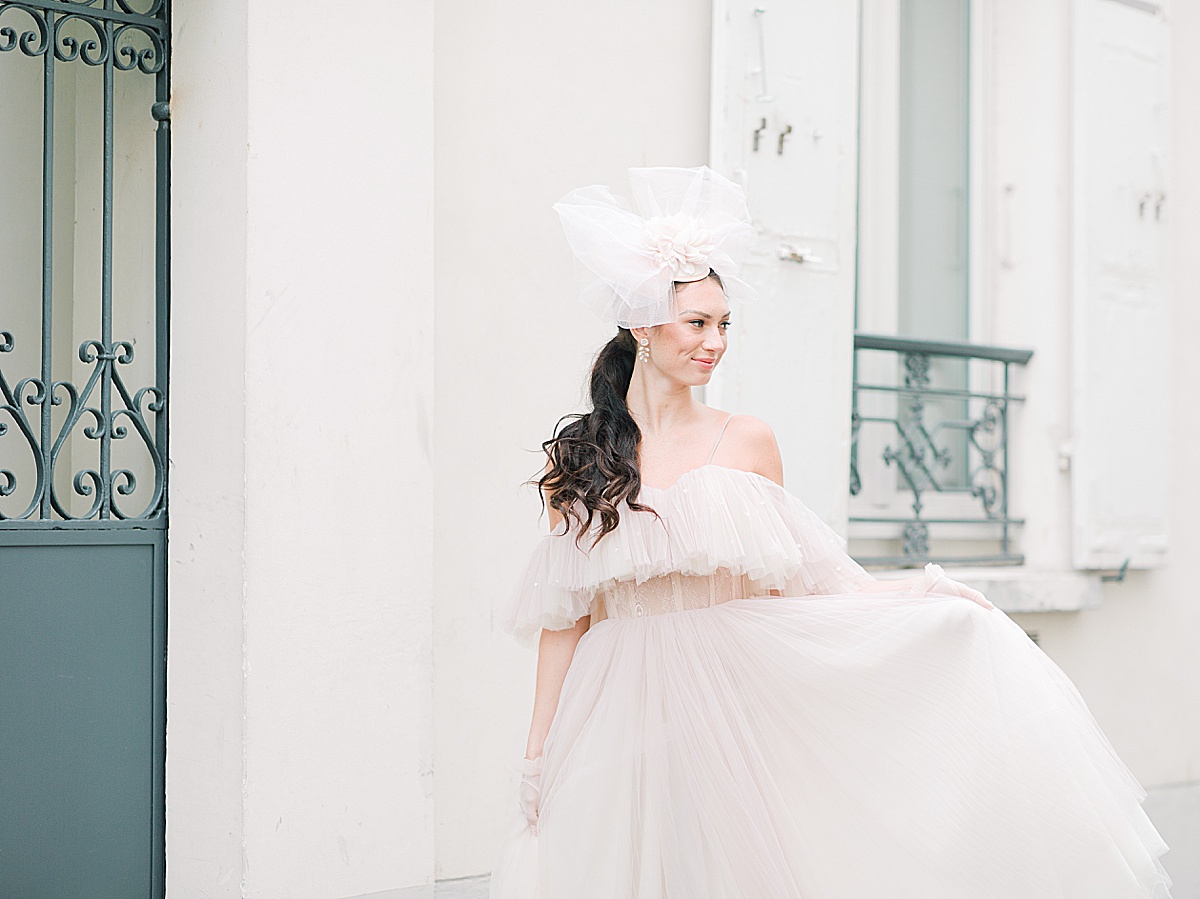 Paris Bridal Fashion Editorial Katie holding up dress looking off Photo