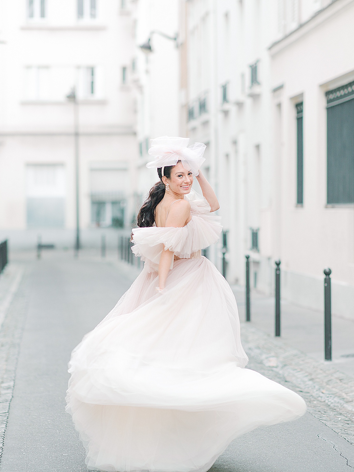 Paris Bridal Fashion Editorial Katie running down street smiling over her shoulder Photo