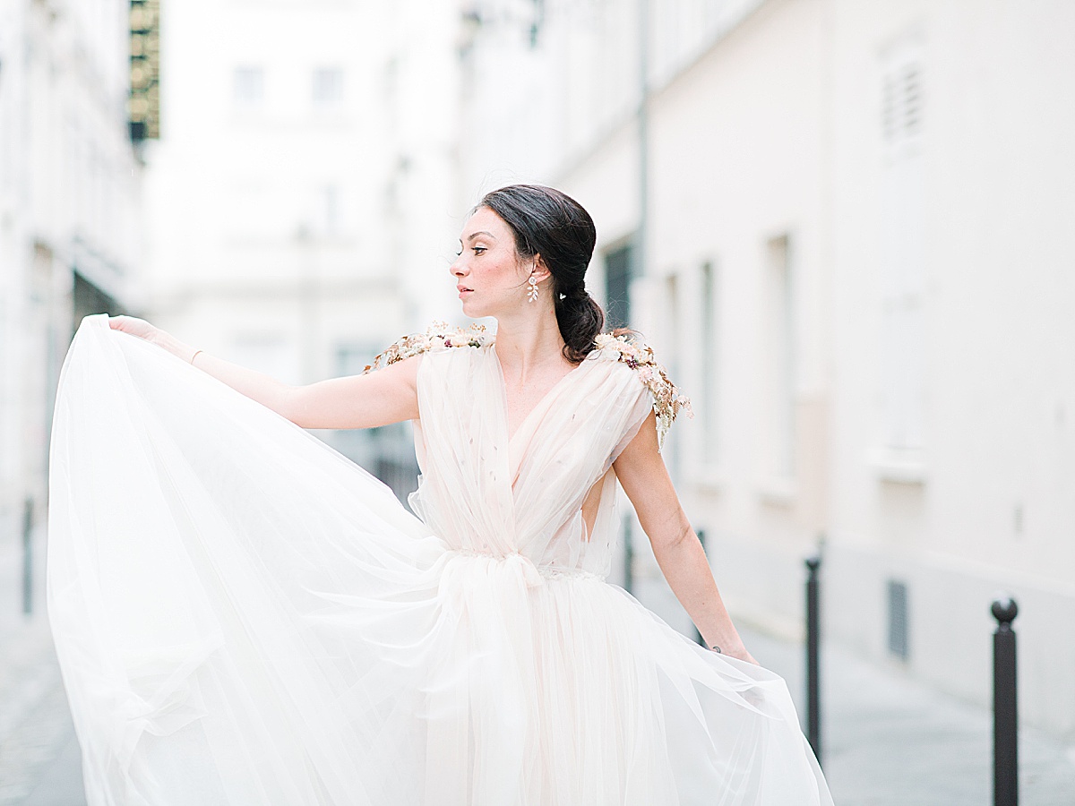Paris Bridal Fashion Editorial Bride holding dress looking off Photo