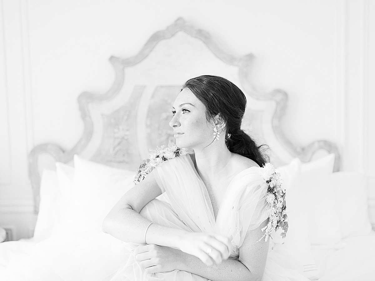 Paris Bridal Fashion Editorial black and white of girl looking off sitting on bed Photo