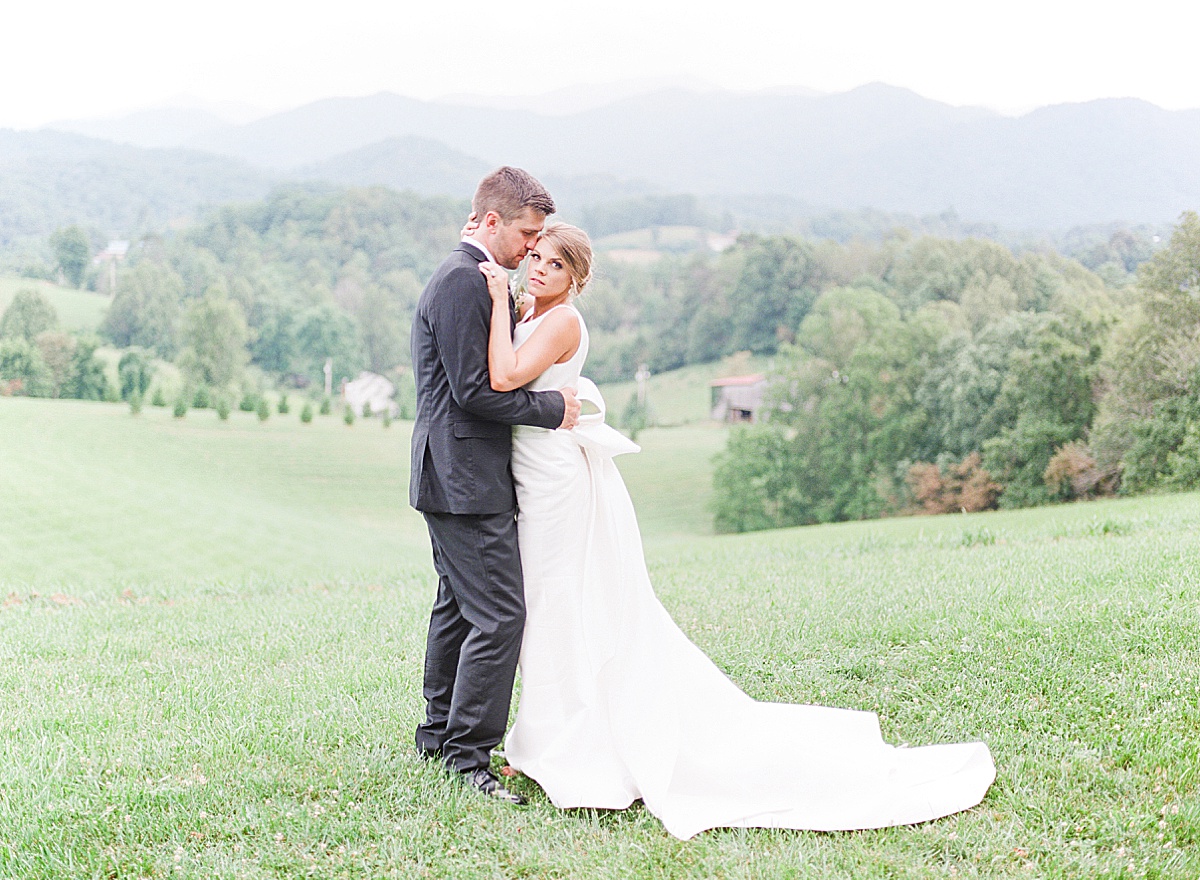 The Ridge Asheville Wedding Bride looking at camera snuggling Groom Photo