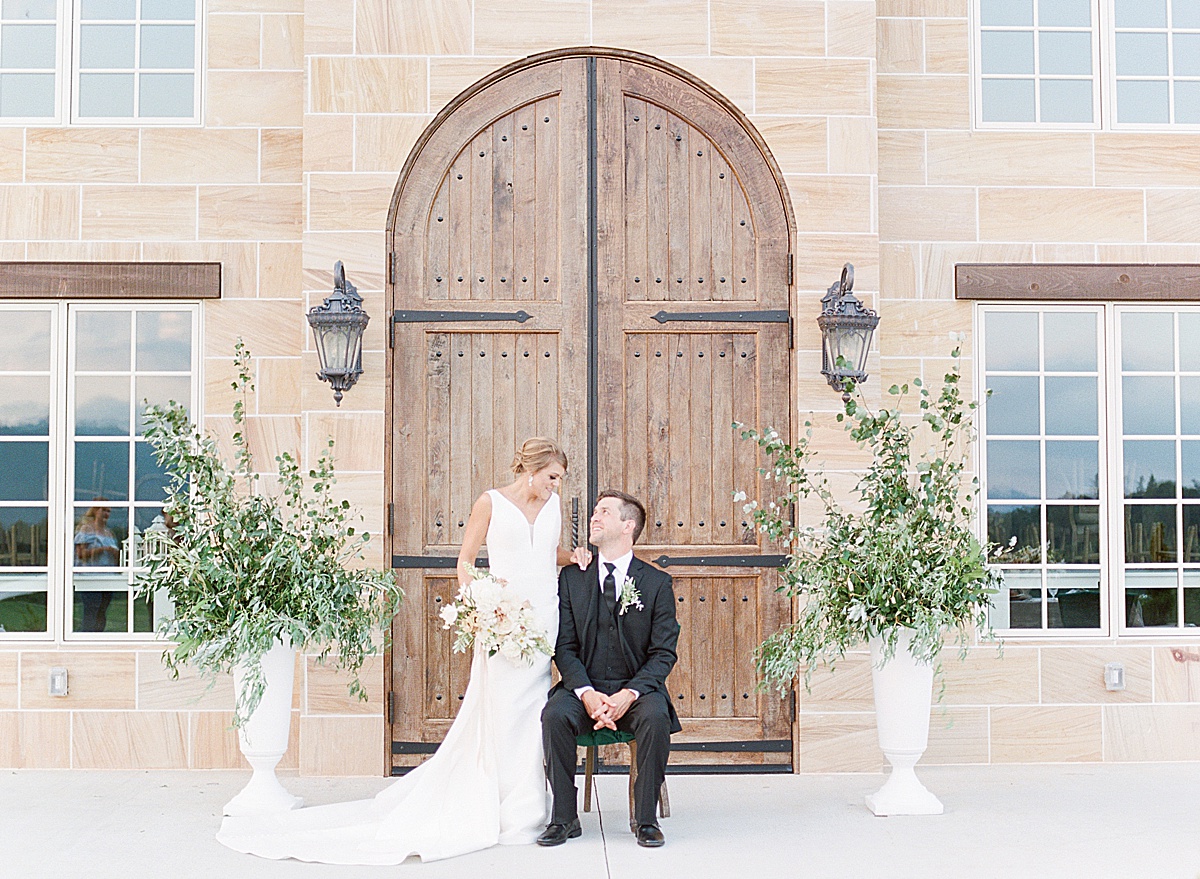 The Ridge Asheville Wedding Couple looking at each other in front of wood doors of chateau Photo