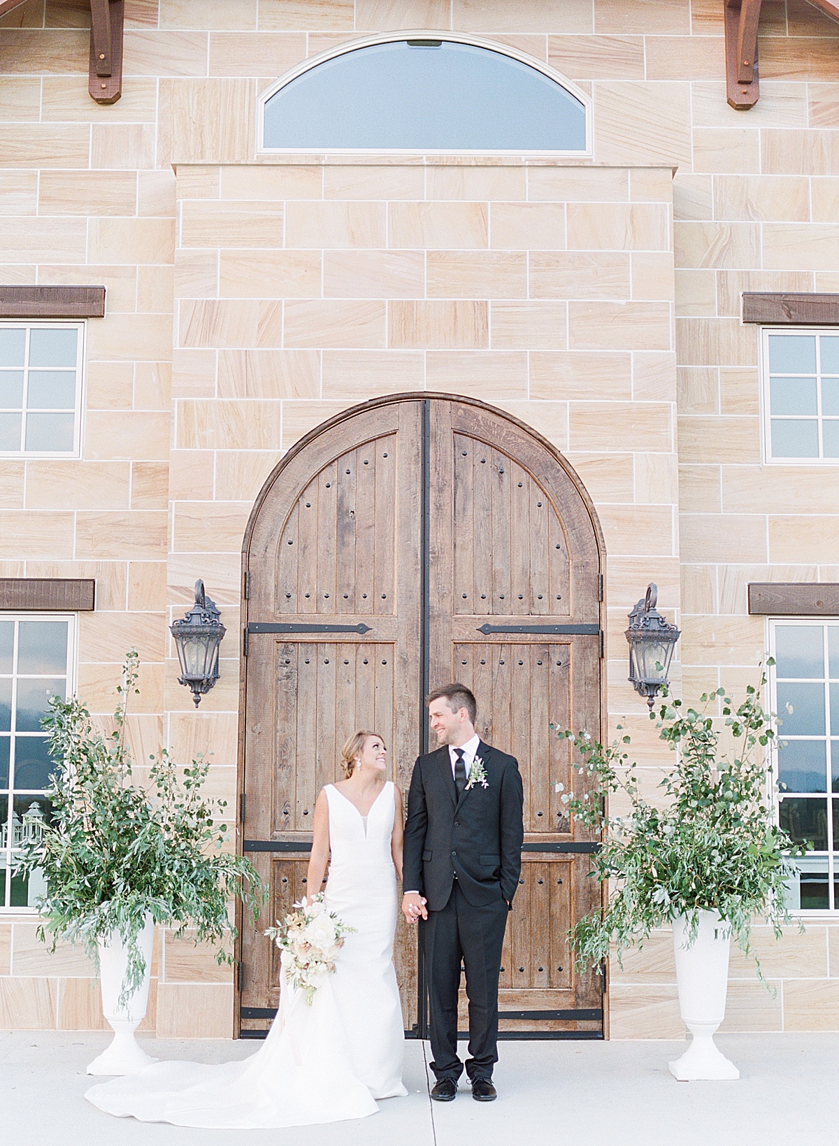 The Ridge Asheville Wedding couple smiling holding hands in front of wood doors Photo