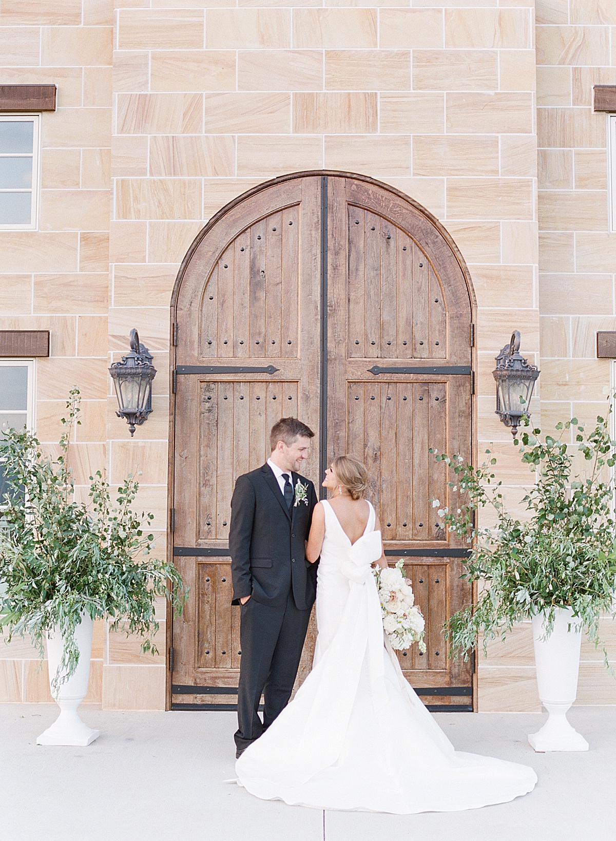The Ridge Asheville Wedding Couple smiling at each other in front of wood doors of chateau Photo