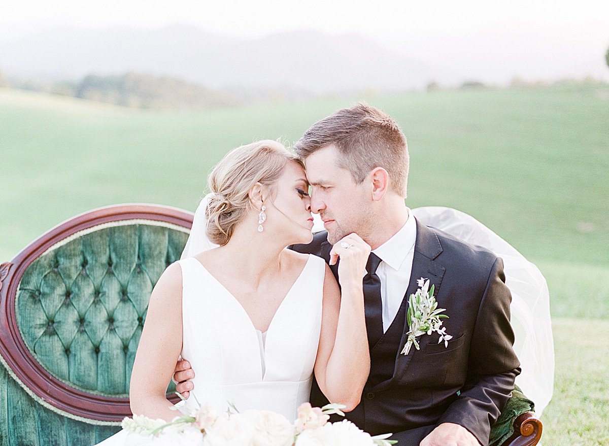 The Ridge Asheville Wedding Bride and Groom Nose to Nose on Green Couch Photo