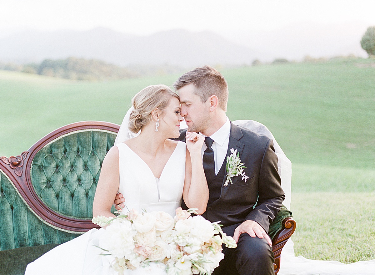 The Ridge Asheville Wedding Bride and Groom Nose to Nose on Green Couch Photo