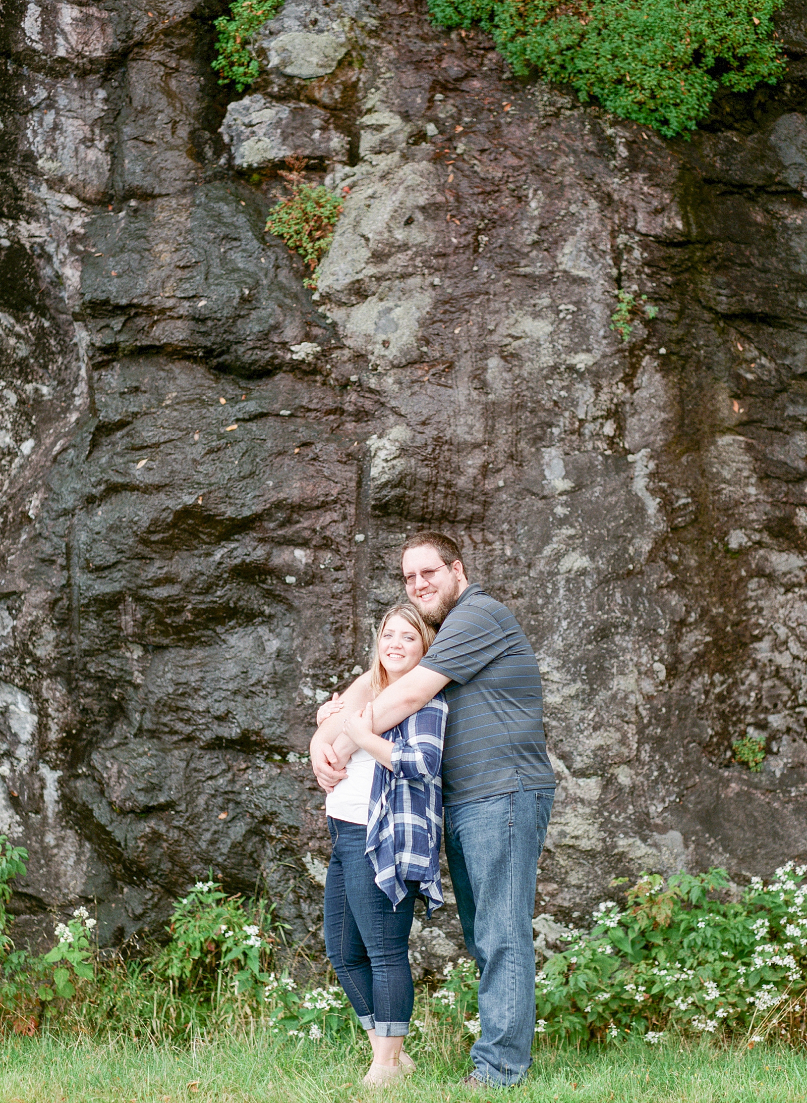Blue Ridge Parkway Engagement Couple Hugging in front of Rock Wall Photo