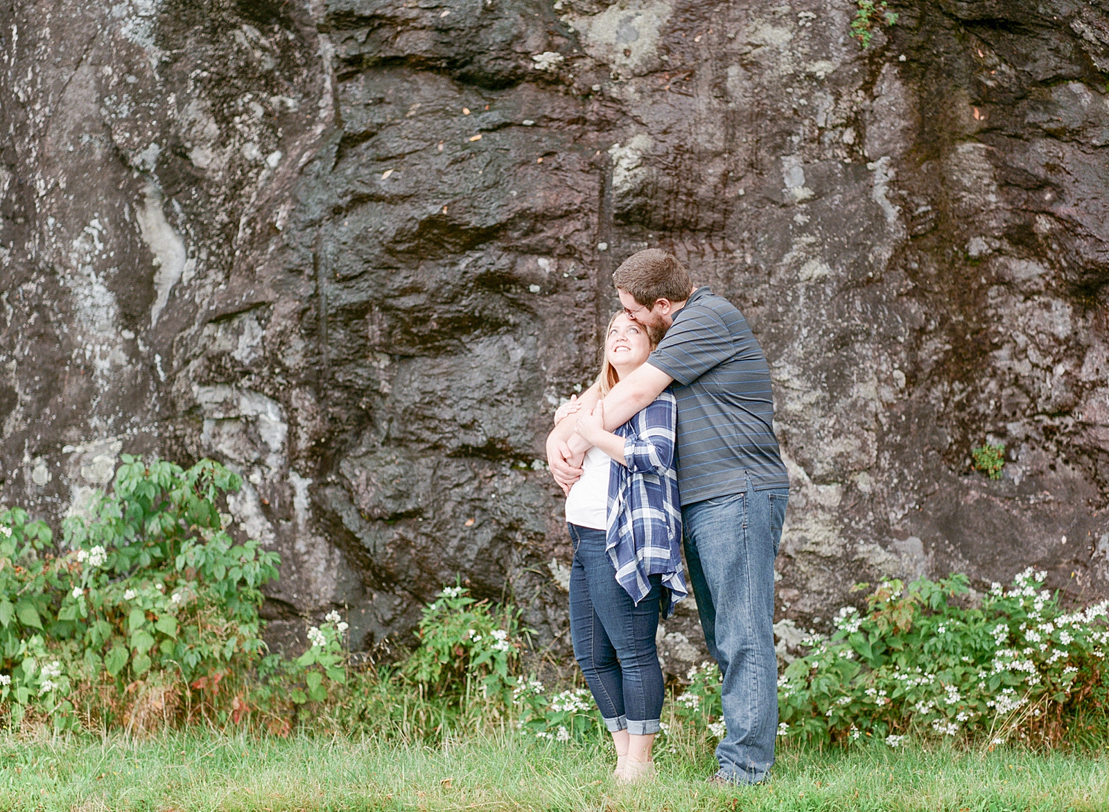 Blue Ridge Parkway Engagement Couple Hugging in Front of Rock Wall Photo