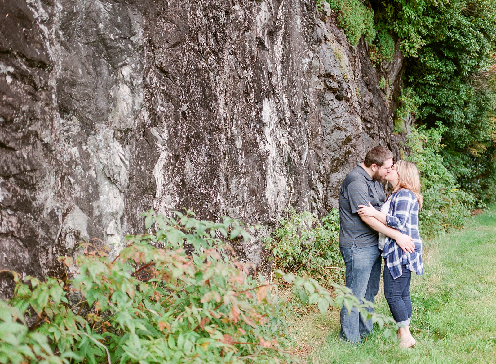 Blue Ridge Parkway Engagement Couple Kissing in Front of Rock Wall Photo