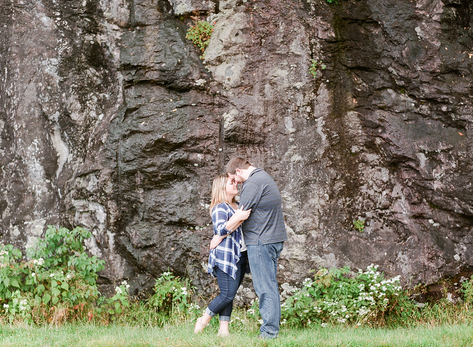 Blue Ridge Parkway Engagement Couple Nose to Nose in Front of Rock Wall Photo
