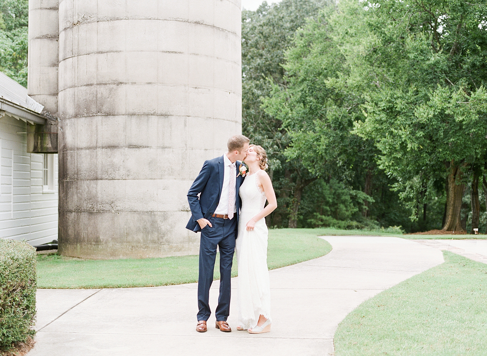 Dairy Barn Wedding Bride and Groom Kissing In Front of Silo Photo