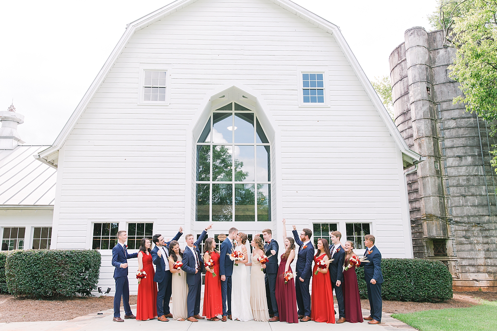 Dairy Barn Wedding Bride and Groom Kissing and Bridal Party Cheering Photo