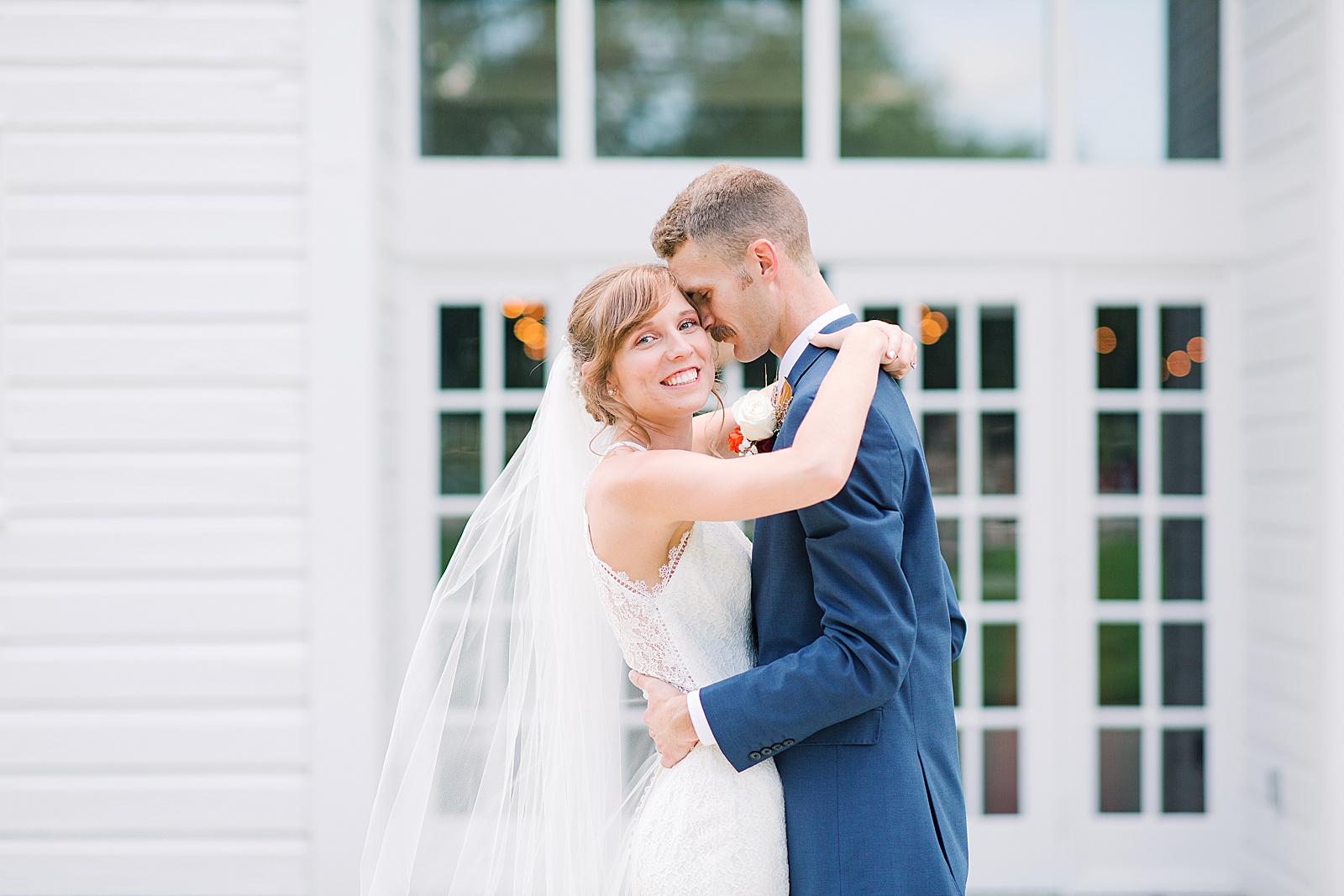 Dairy Barn Wedding Bride Smiling and Groom Snuggling Photo