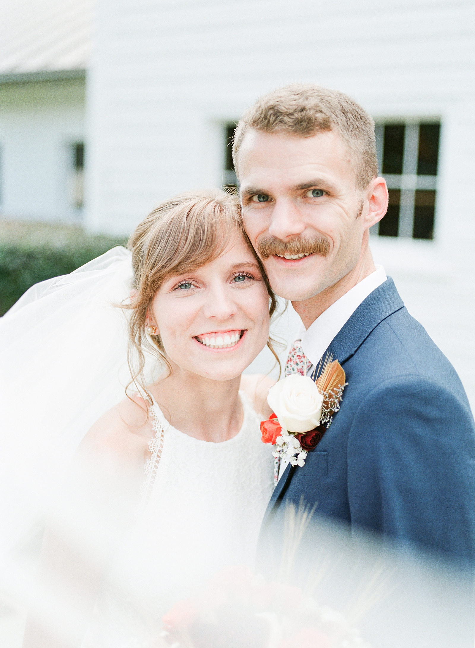 Dairy Barn Wedding Bride and Groom Smiling at camera with veil sweeping in front Photo