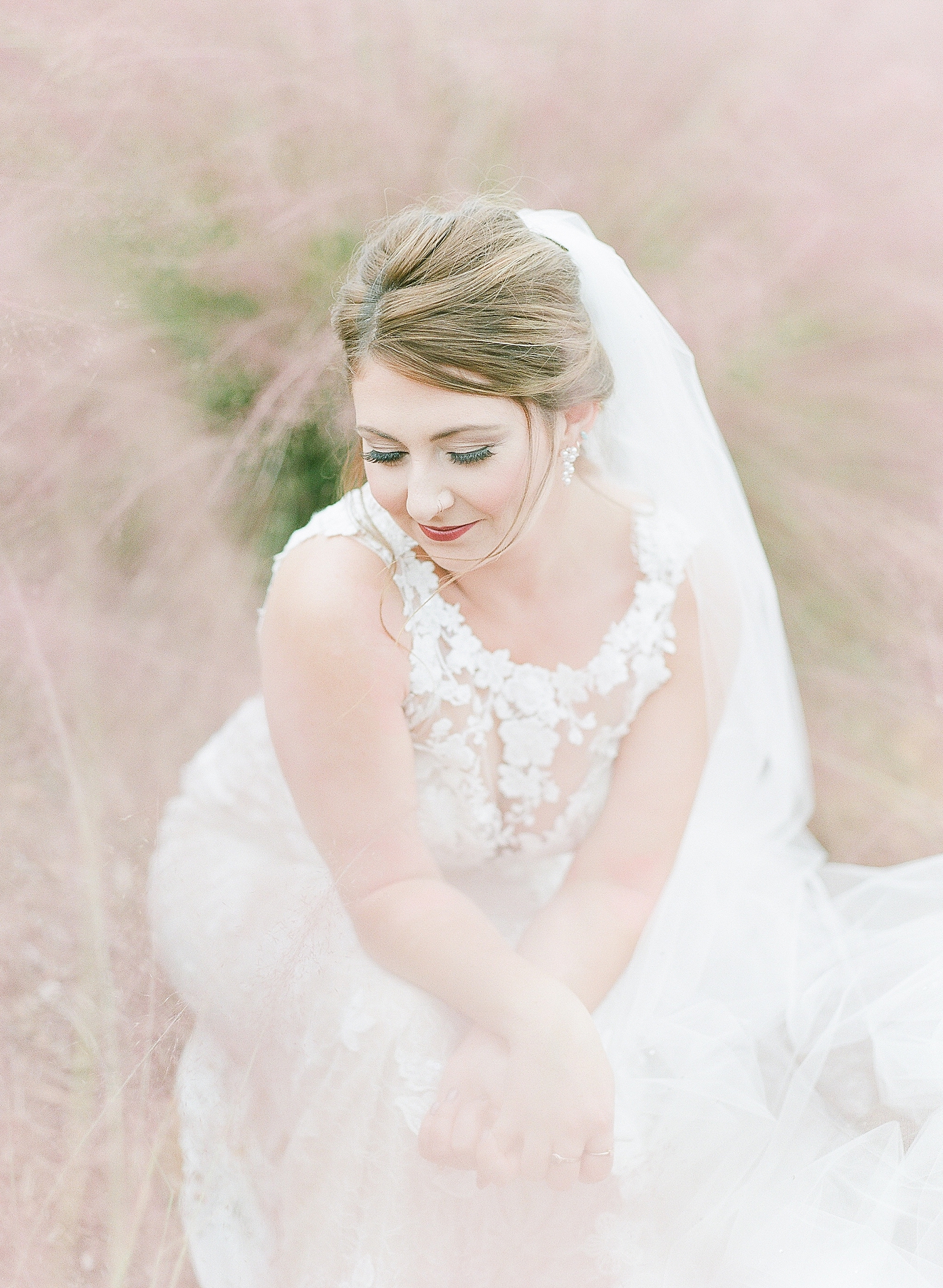 Asheville Bridal Editorial Bride Sitting in Mauve Flowers Looking Down Photo