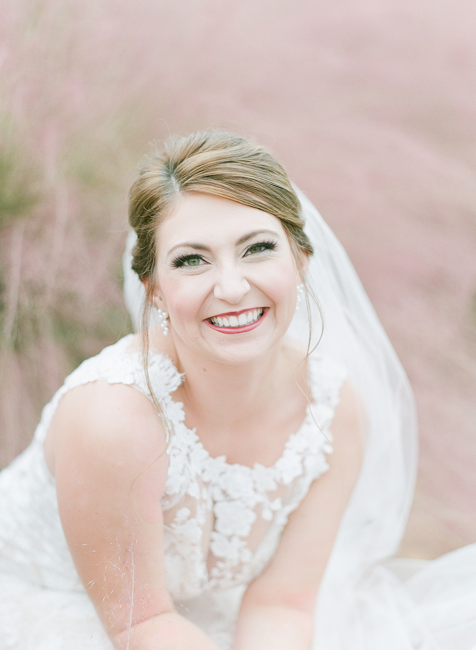 Asheville Bridal Editorial Bride Smiling at Camera surrounded by Mauve Flowers Photo