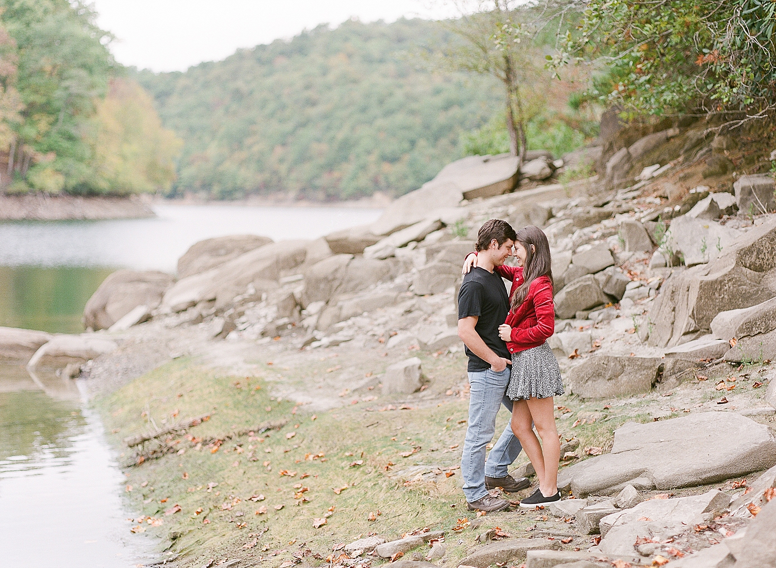 Mountaintop Engagement Couple Nose to nose on Rocks at lake Photo 