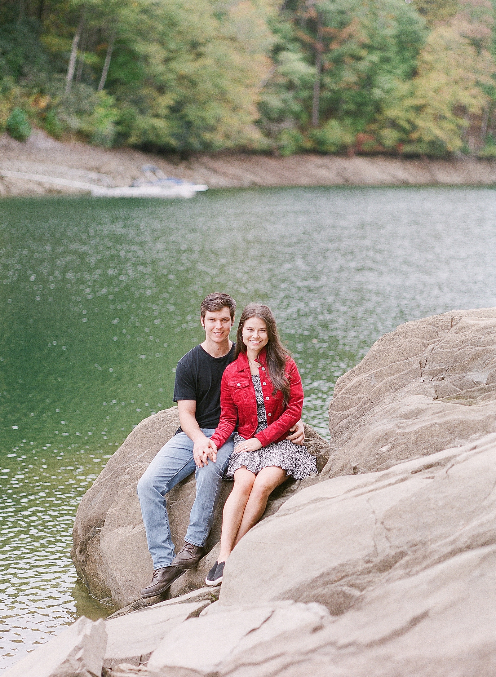 Mountaintop Engagement Couple Smiling at Camera sitting on rocks Photo 
