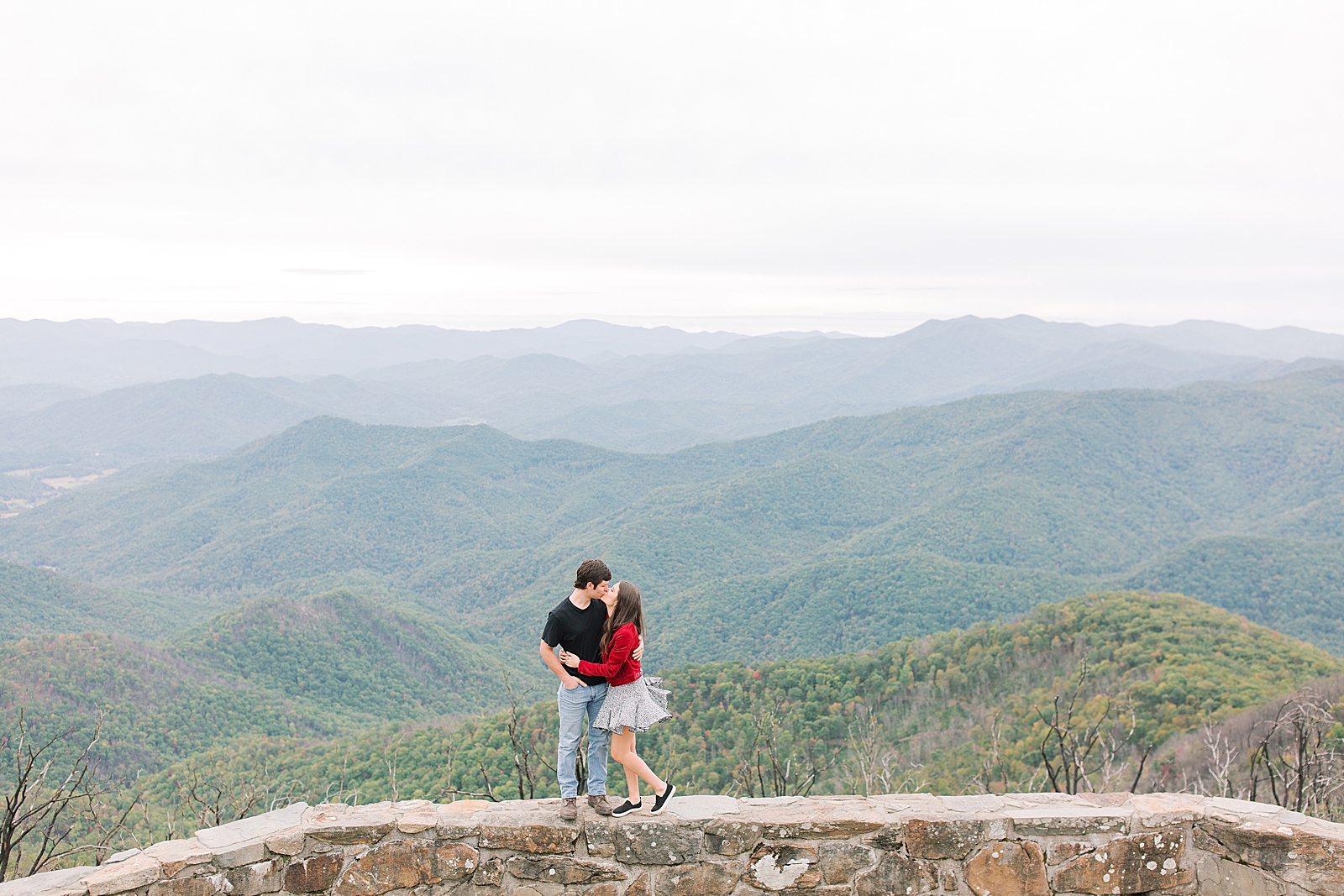 Mountaintop Engagement Couple Kissing on Wall Photo 