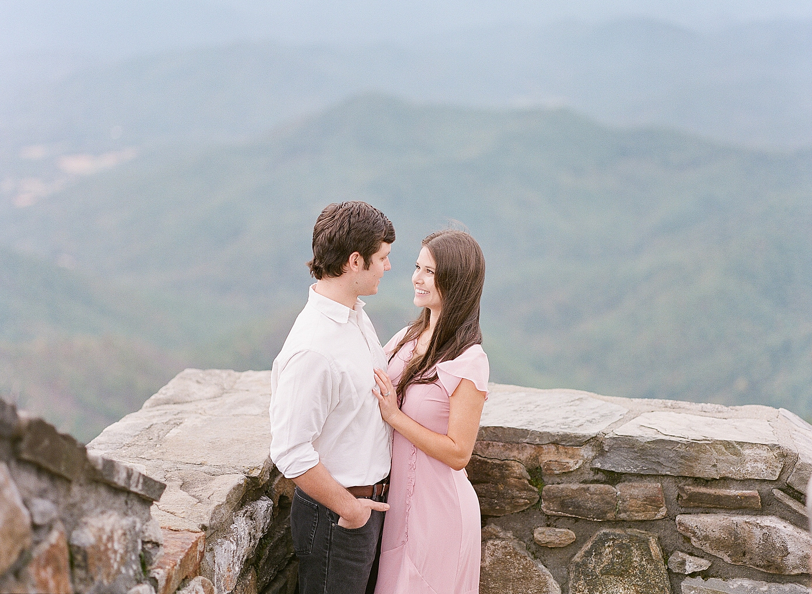 Mountaintop Engagement Couple smiling at each other Photo 