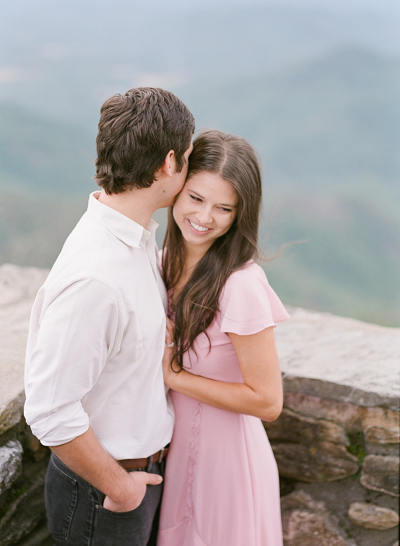 Mountaintop Engagement Couple Hugging and Laughing Photo 