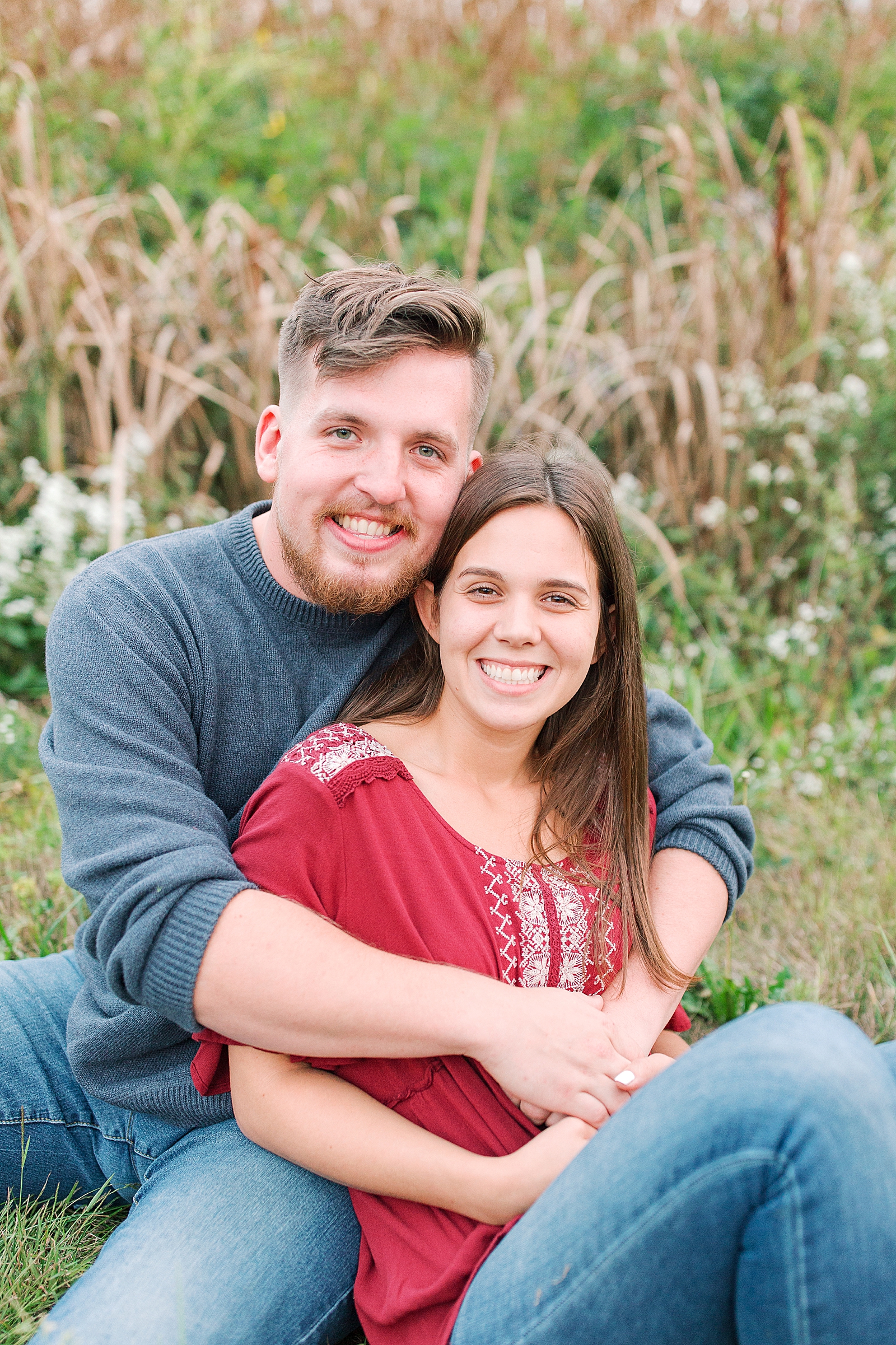  North Carolina Mountain Engagement Session Couple Sitting in Grass Smiling at Camera Photo