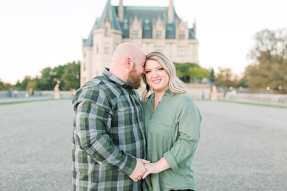 Biltmore Estate Engagement Session Kaley Smiling at Camera and Ryan Snuggling In Photo