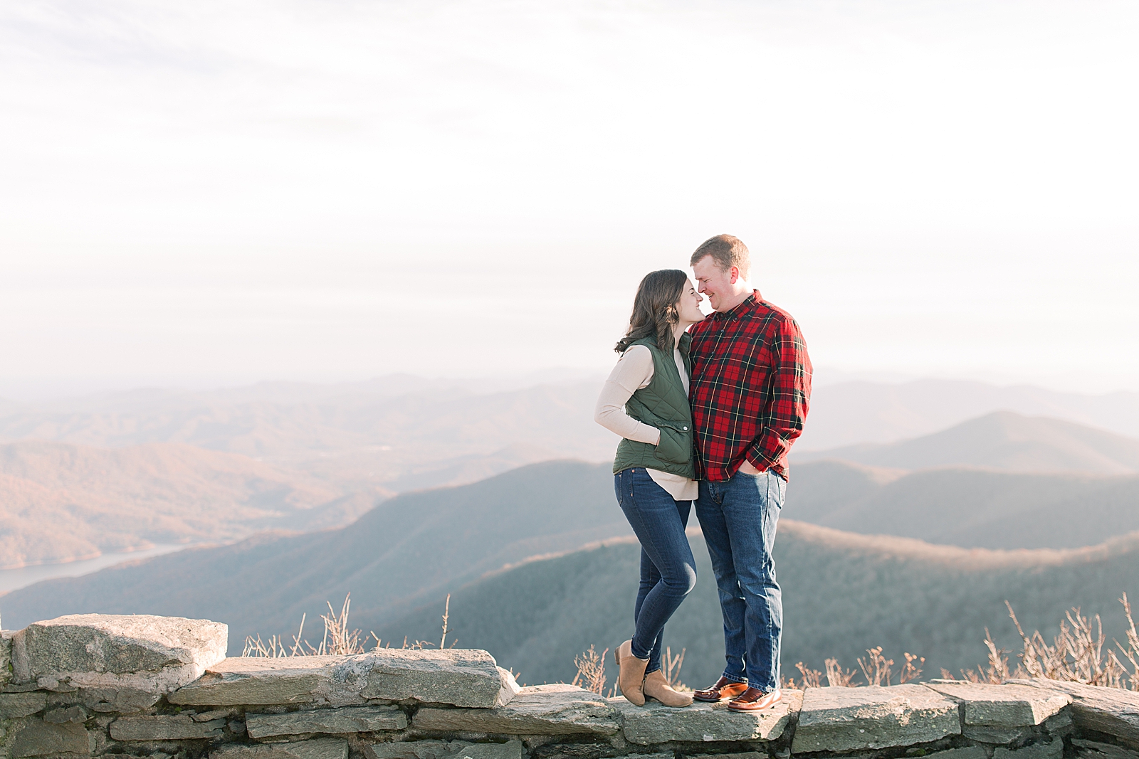 Craggy Gardens Trail Engagement Session Couple Nose to Nose on Wall with Mountain background Photo