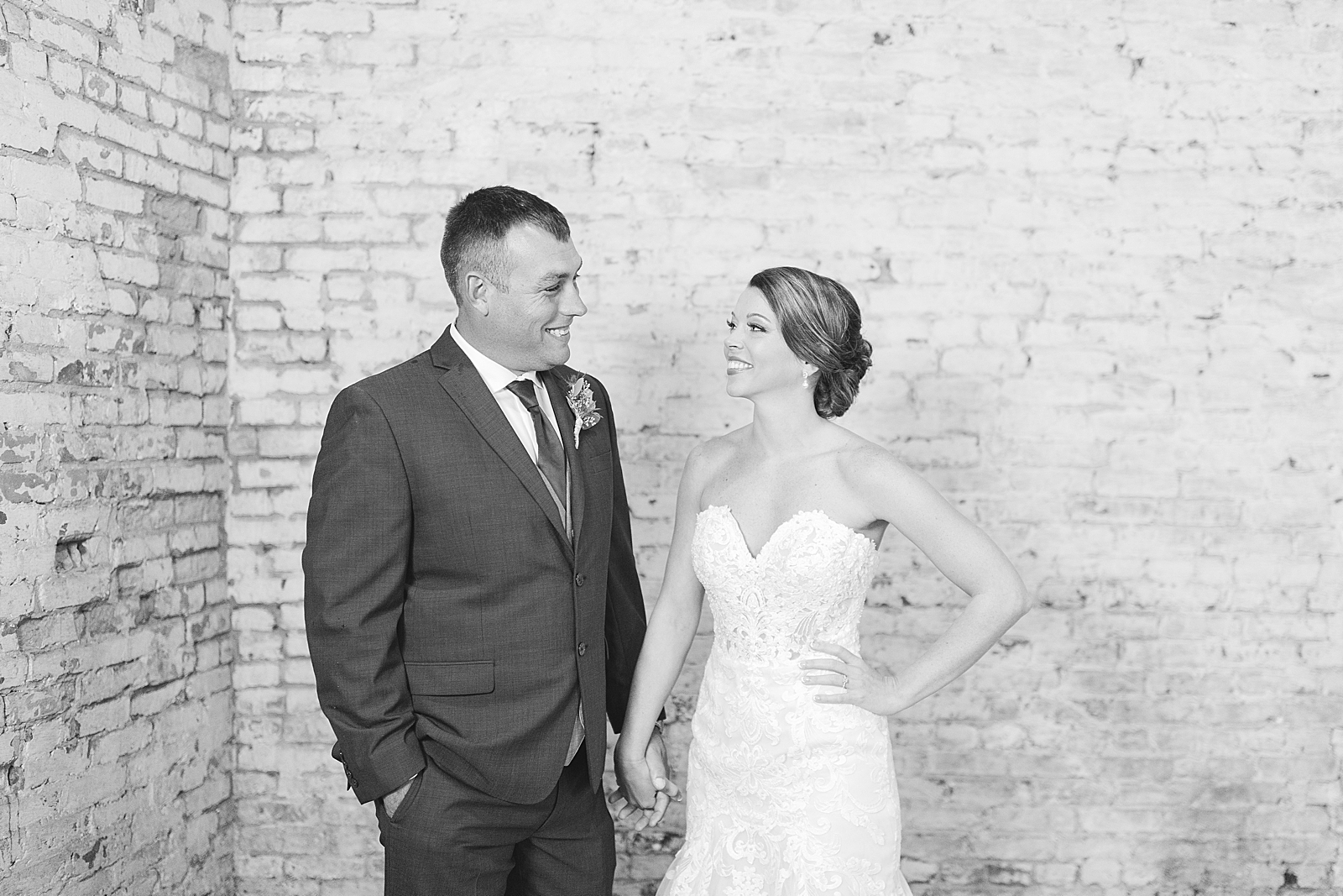 The Hackney Warehouse Black and White of Bride and Groom Smiling at each other holding hands Photo