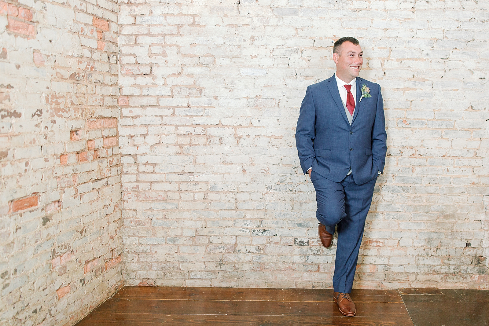 The Hackney Warehouse Groom Leaning on Wall Smiling Photo