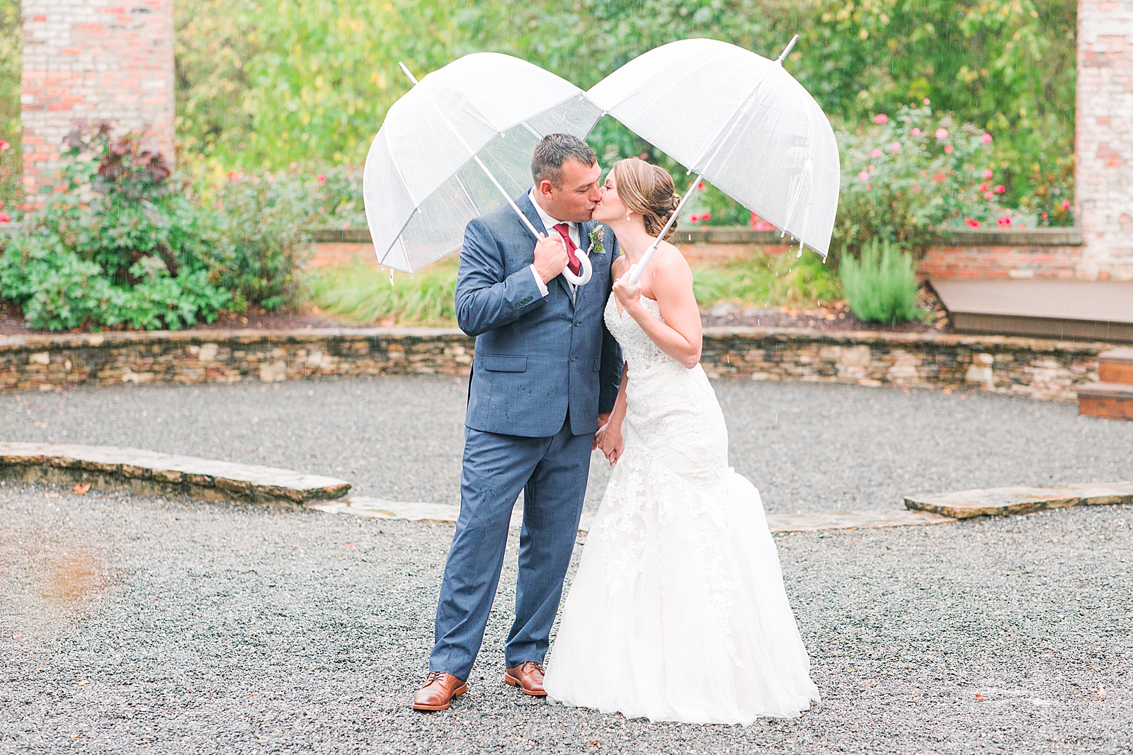 The Hackney Warehouse Rainy Day Wedding Bride and Groom Kissing Under Umbrellas Photo